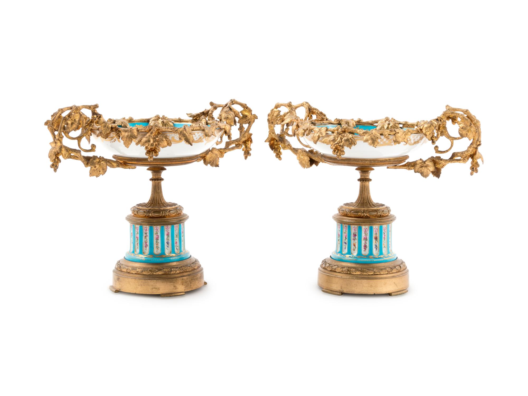 A Pair of Sèvres Style Gilt Bronze Mounted Painted and Parcel Gilt Porcelain Tazze