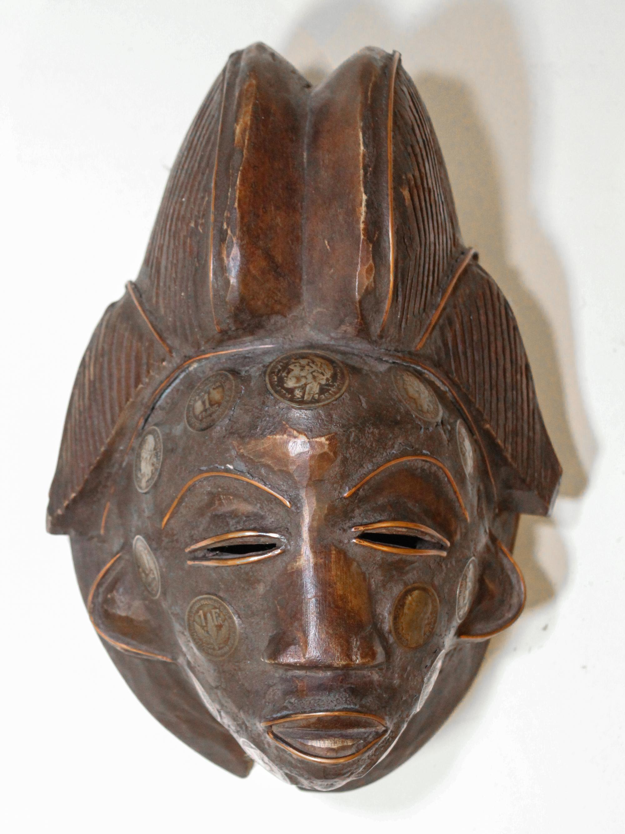 An African Carved Wood Mask, Ivory Coast Length 10 1/2 inches.