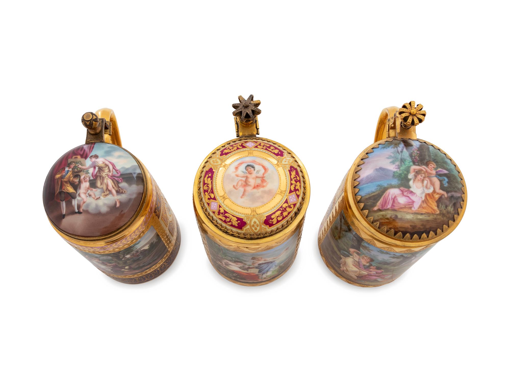 Three Vienna Painted and Parcel Gilt Porcelain Tankards