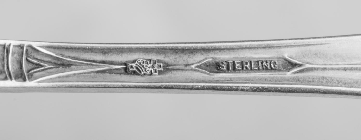 Gadroonette pattern with an engraved monogram, comprising: 12 dinner knives 12 dinner forks 12 salad forks 12 cocktail forks 12 teaspoons 12 soup spoons 12 iced tea spoons 12 citrus spoons 12 butter spreaders 3 table spoons 2 sugar scoops 1 cold meat fork 1 tomato server 1 sauce ladle 1 cake slice 1 poultry shears 1 two-piece carving set 120 items total.