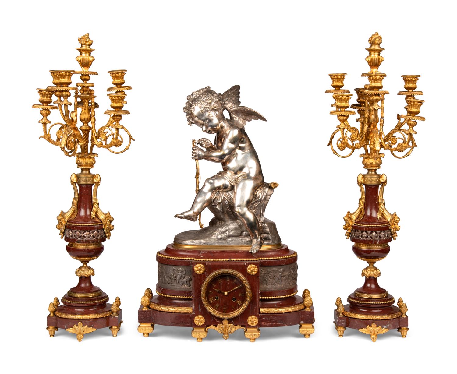 A French Gilt and Silvered Bronze and Rouge Marble Three-Piece Clock Garniture