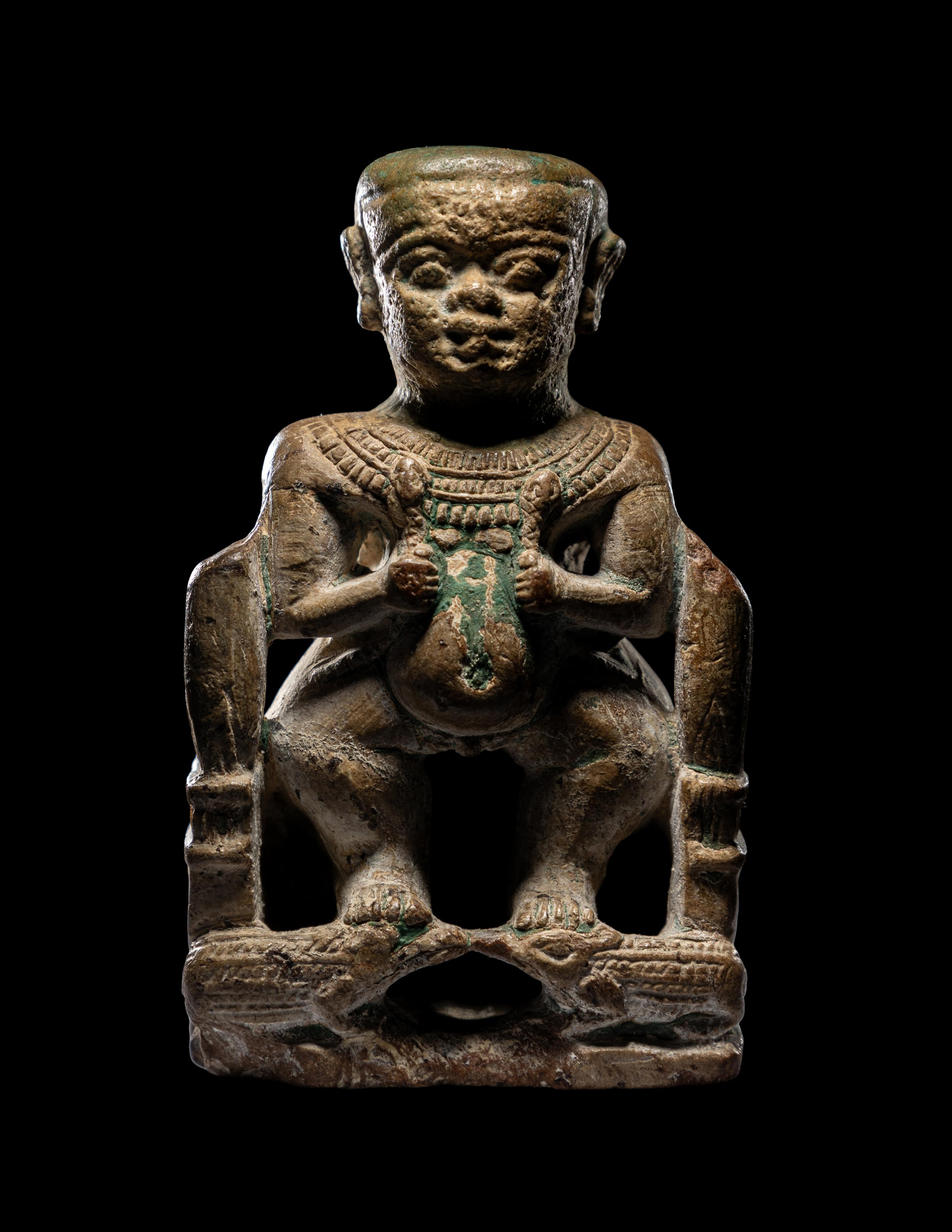 An Egyptian Glazed Steatite Amulet of Pataikos on Crocodiles