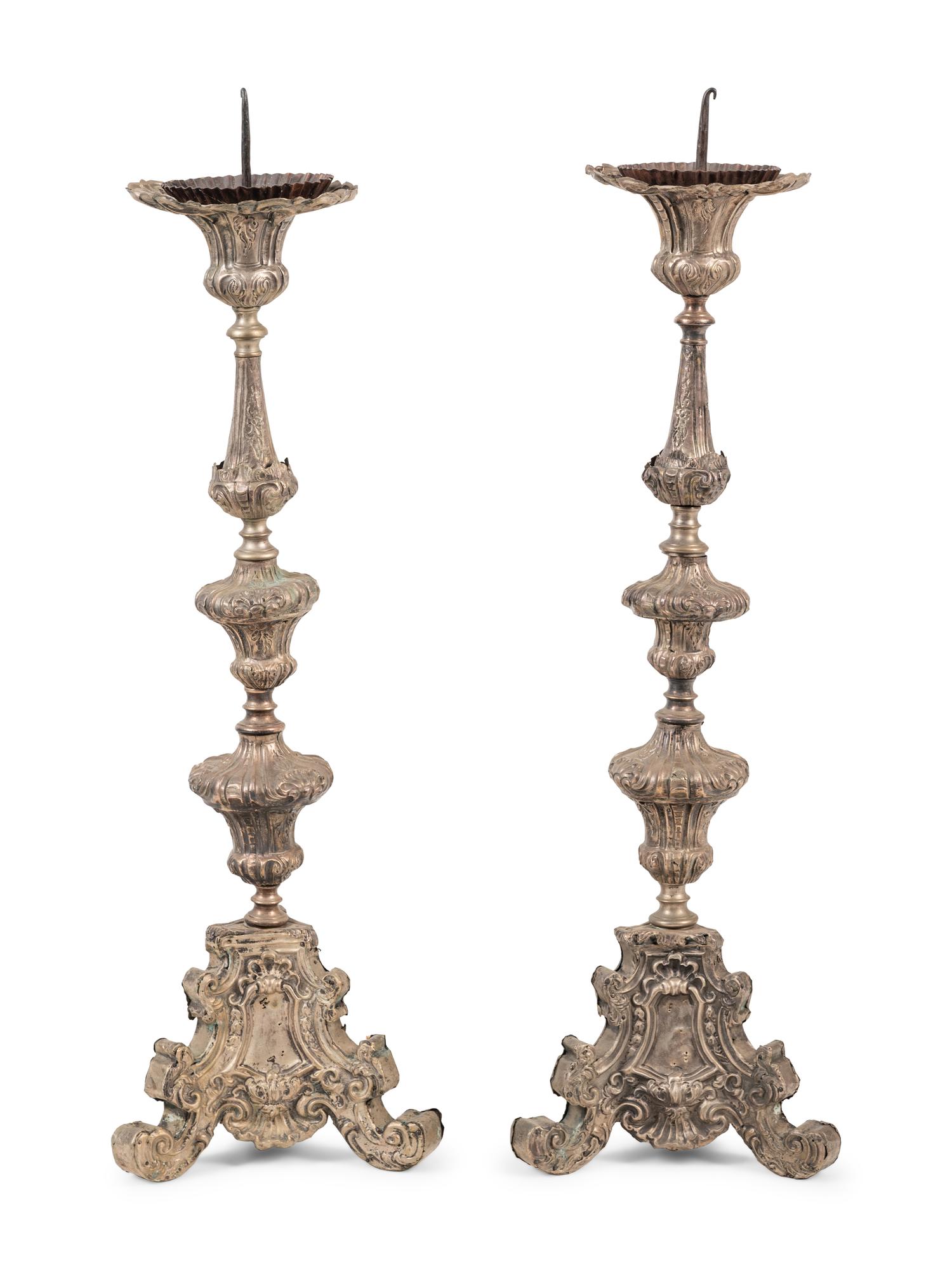 A Pair of Baroque Repoussé Decorated Silvered Metal Pricket Sticks