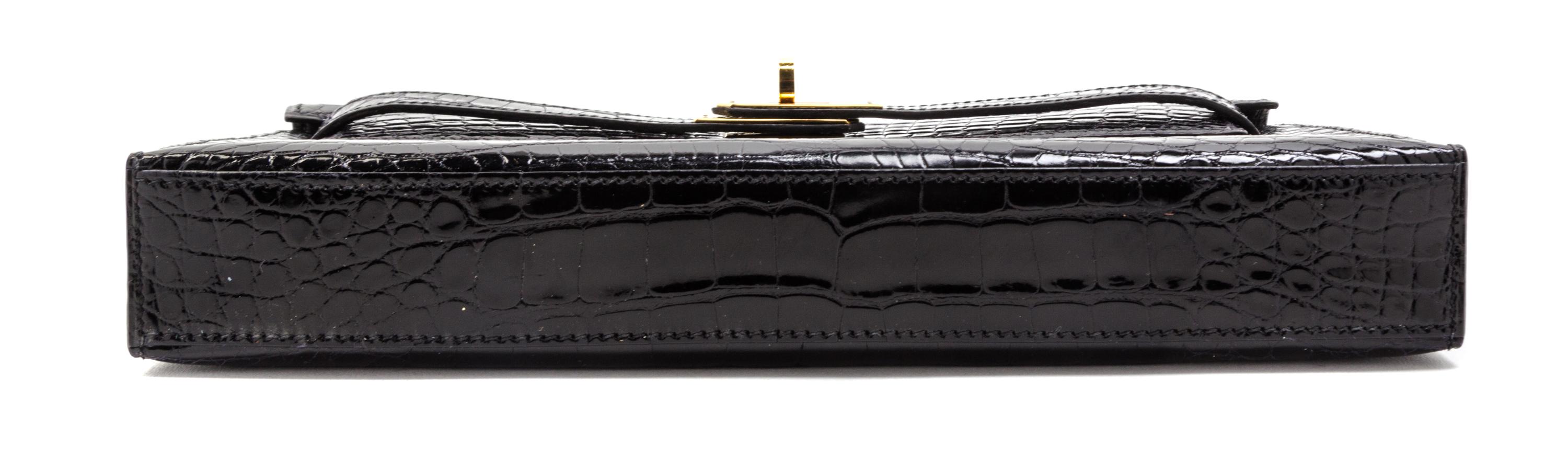 An Hermes Black Shiny Alligator Kelly Clutch Bag, 11 x 6 x 1 1/2 inches.