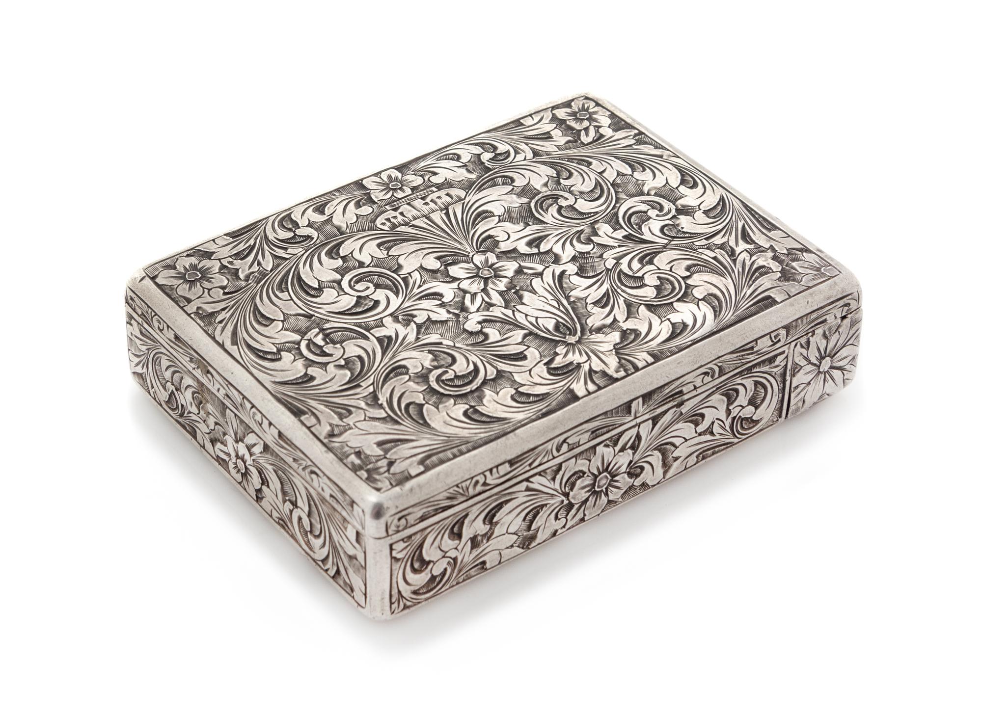 An Italian Silver Compact, First Half 20th Century, the case worked to show floral and foliate scroll decoration, opening to a mirrored