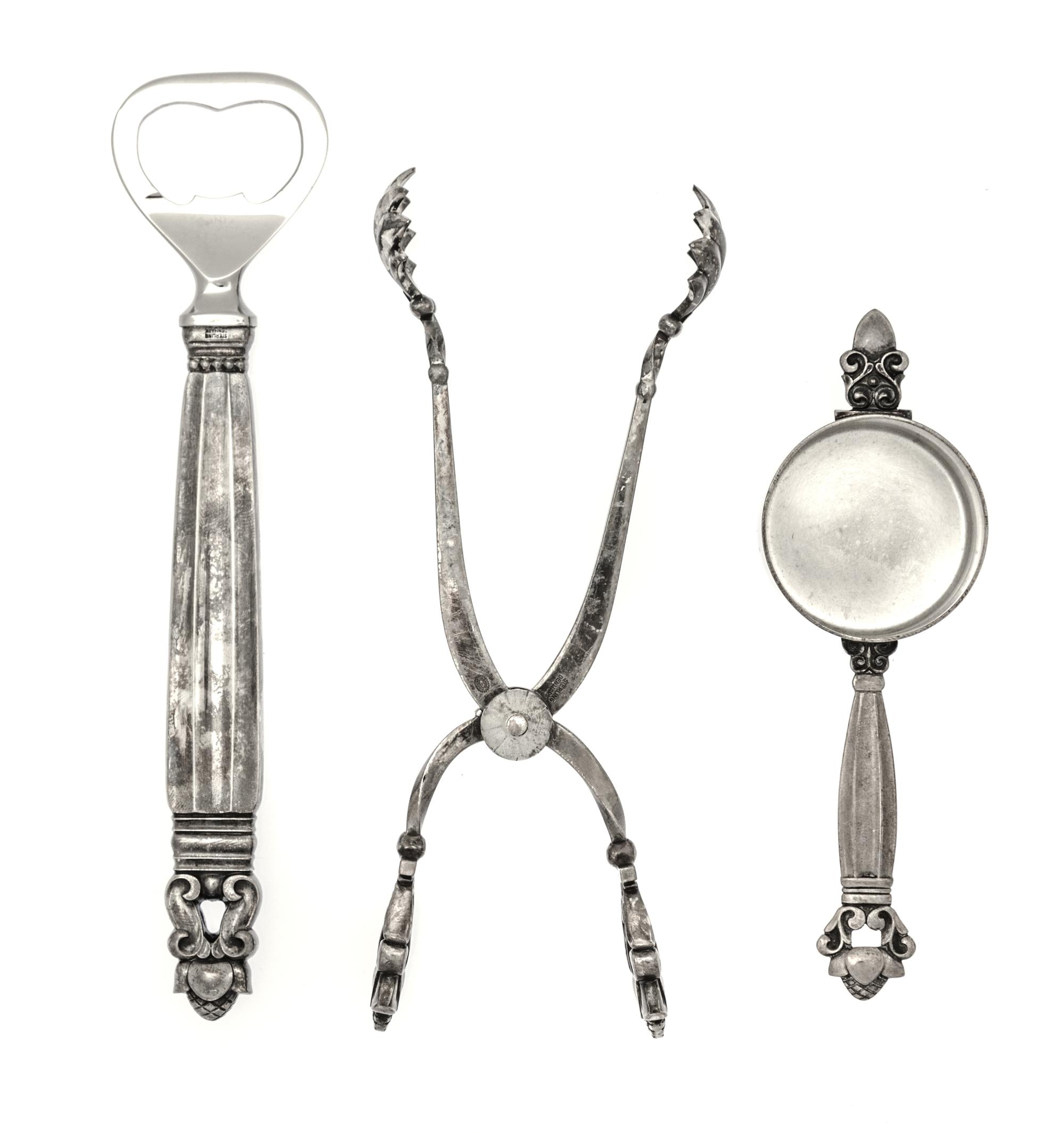 A Danish Silver Three-Piece Bar Set, Georg Jensen, Copenhagen, Acorn pattern, comprising a pair of tongs, a jigger and a bottle opener
