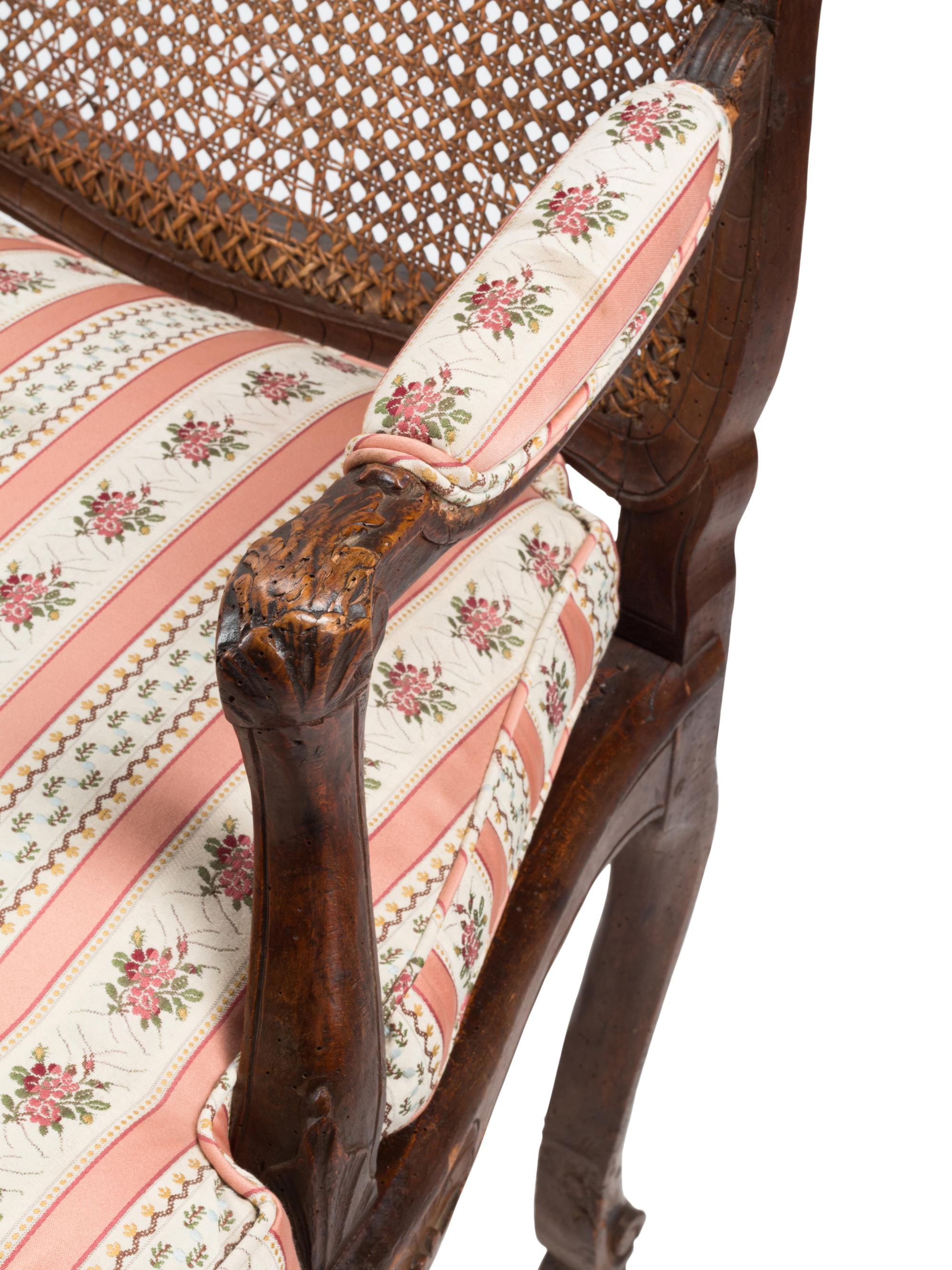 A Pair of Louis XV Provincial Walnut Caned Fauteuils