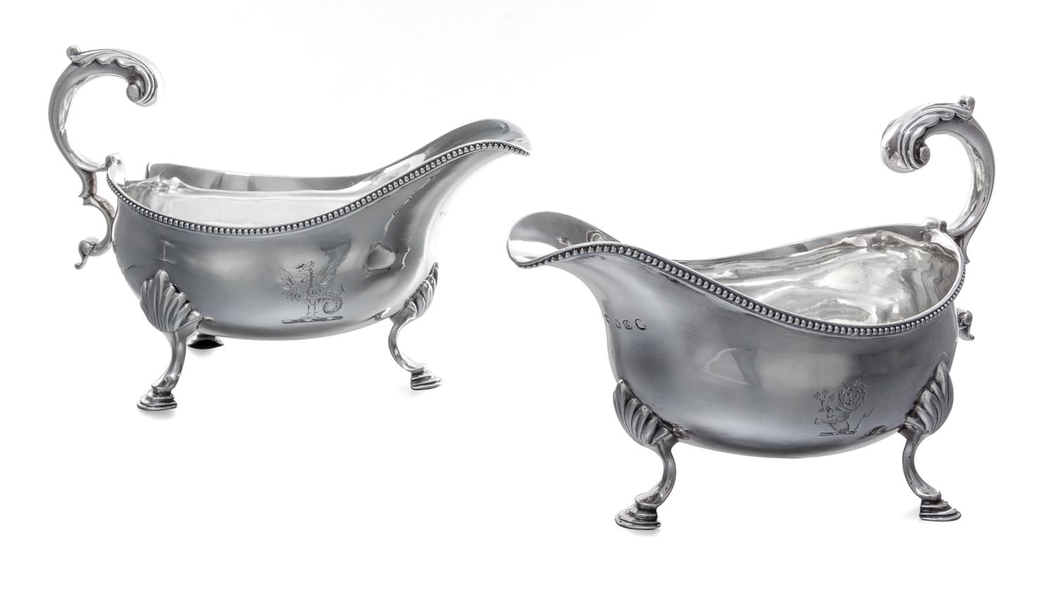 A Pair of George III Silver Sauce Boats, Hester Bateman, London, 1789, each having a foliate scroll handle and a beaded edge, raised on