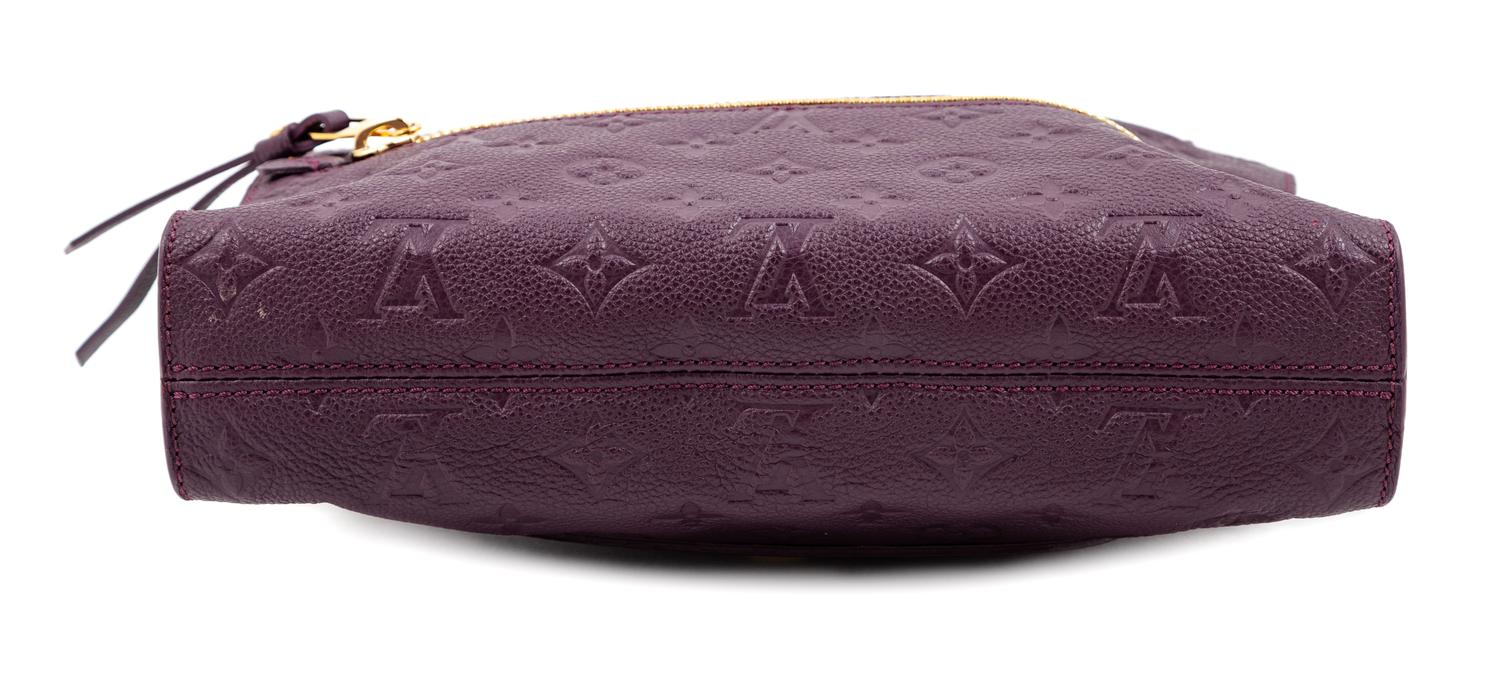 A Louis Vuitton Plum Monogram Empreinte Leather Petillante Clutch, 7" H x 10.75" W x 2.5" D.