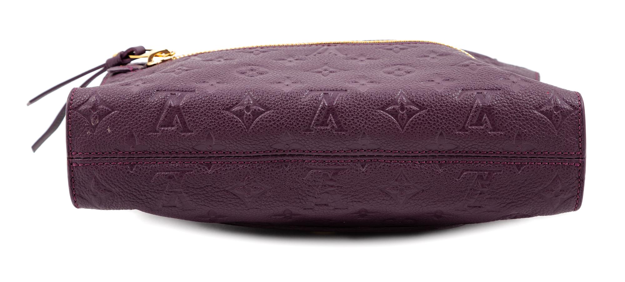A Louis Vuitton Plum Monogram Empreinte Leather Petillante Clutch, 7" H x 10.75" W x 2.5" D.