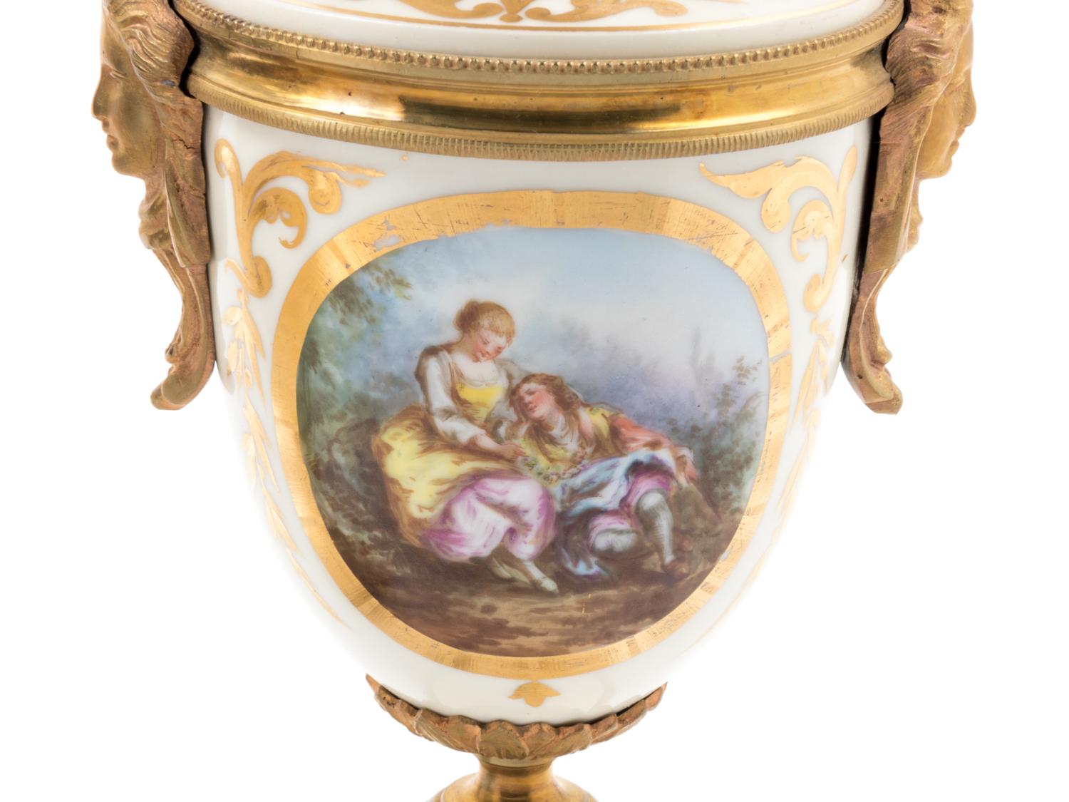 A Pair of Sèvres Style Gilt Bronze Mounted Painted and Parcel Gilt Porcelain Urns