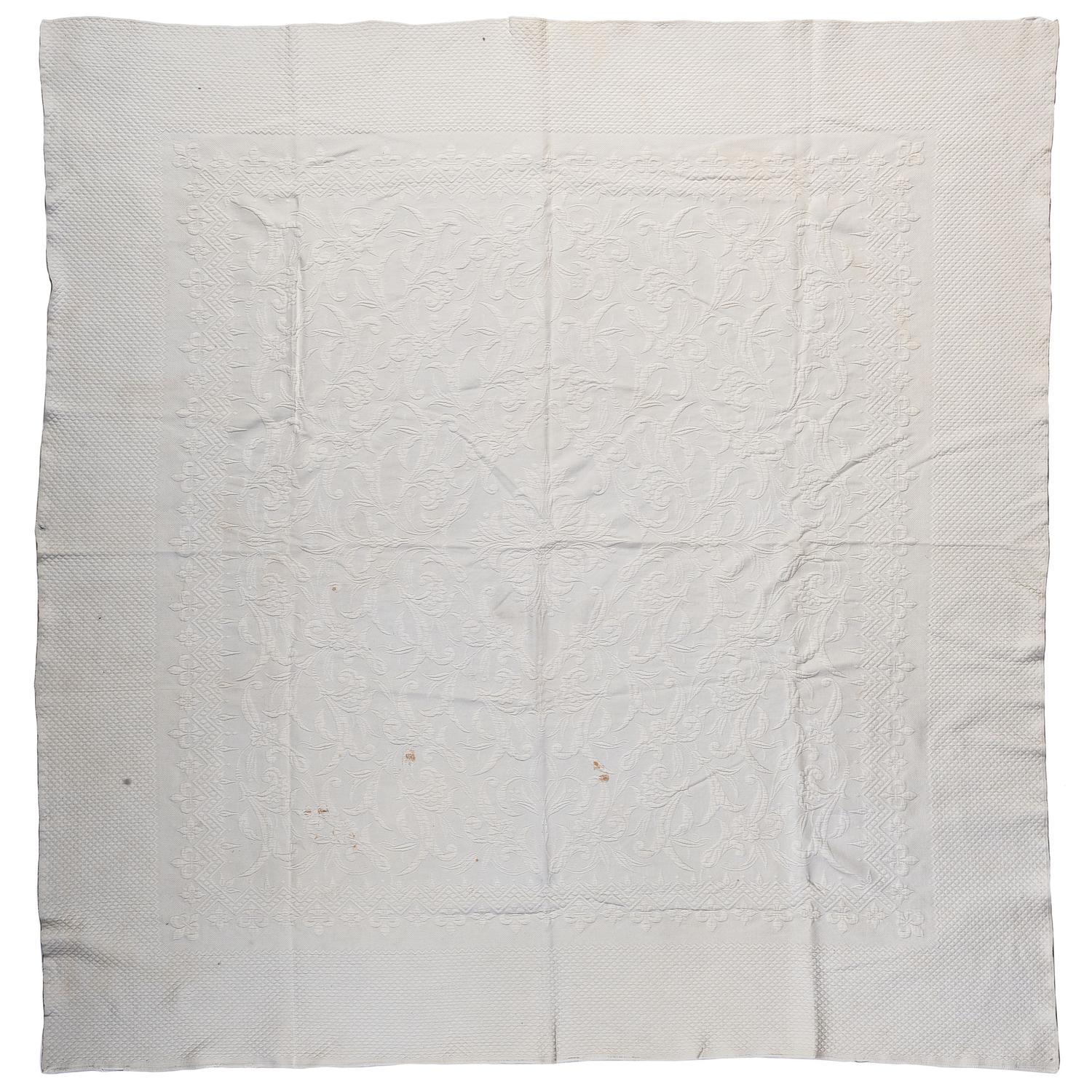 A Pieced Sunburst Quilt and a White Matelasse Coverlet