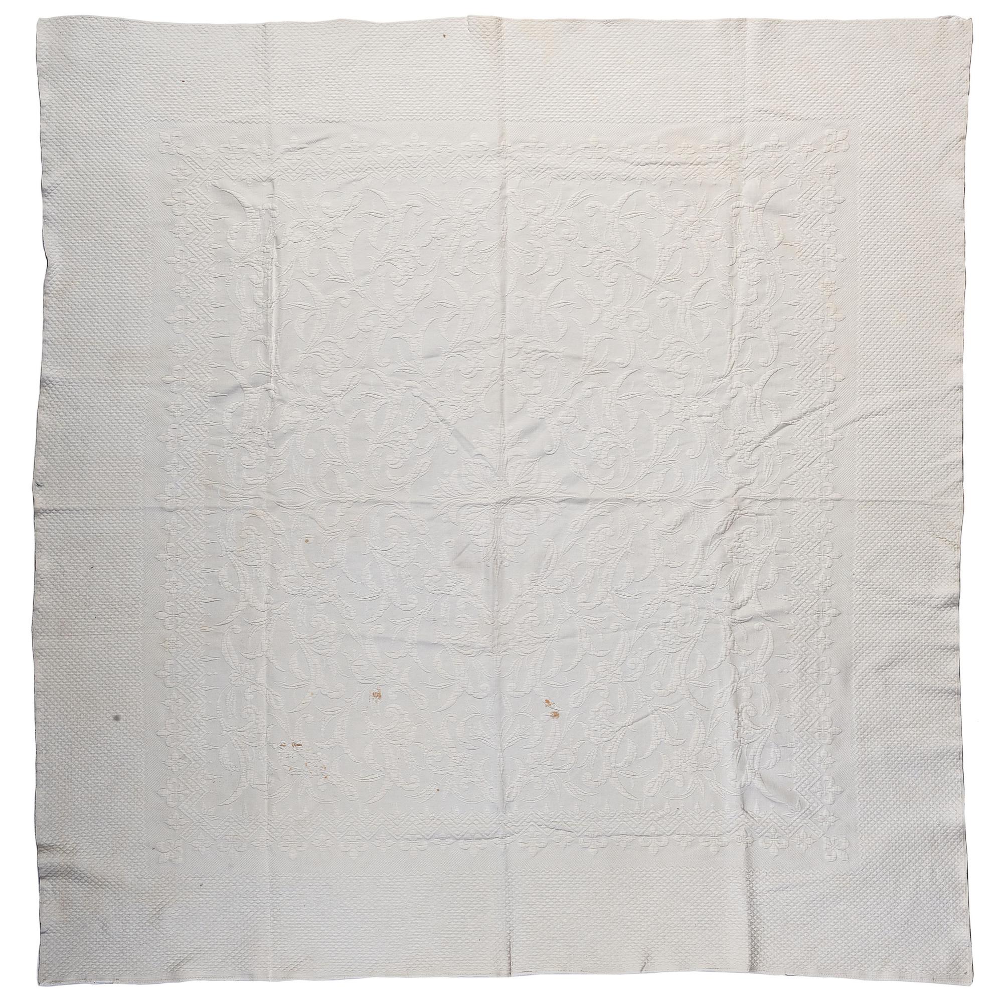 A Pieced Sunburst Quilt and a White Matelasse Coverlet