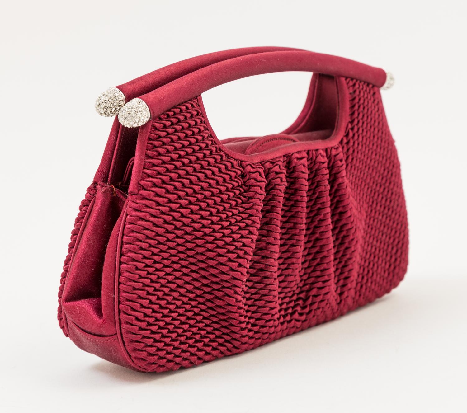 A Judith Leiber Bordeaux Satin Textured Clutch, 8" x 4.5" x 1.5".