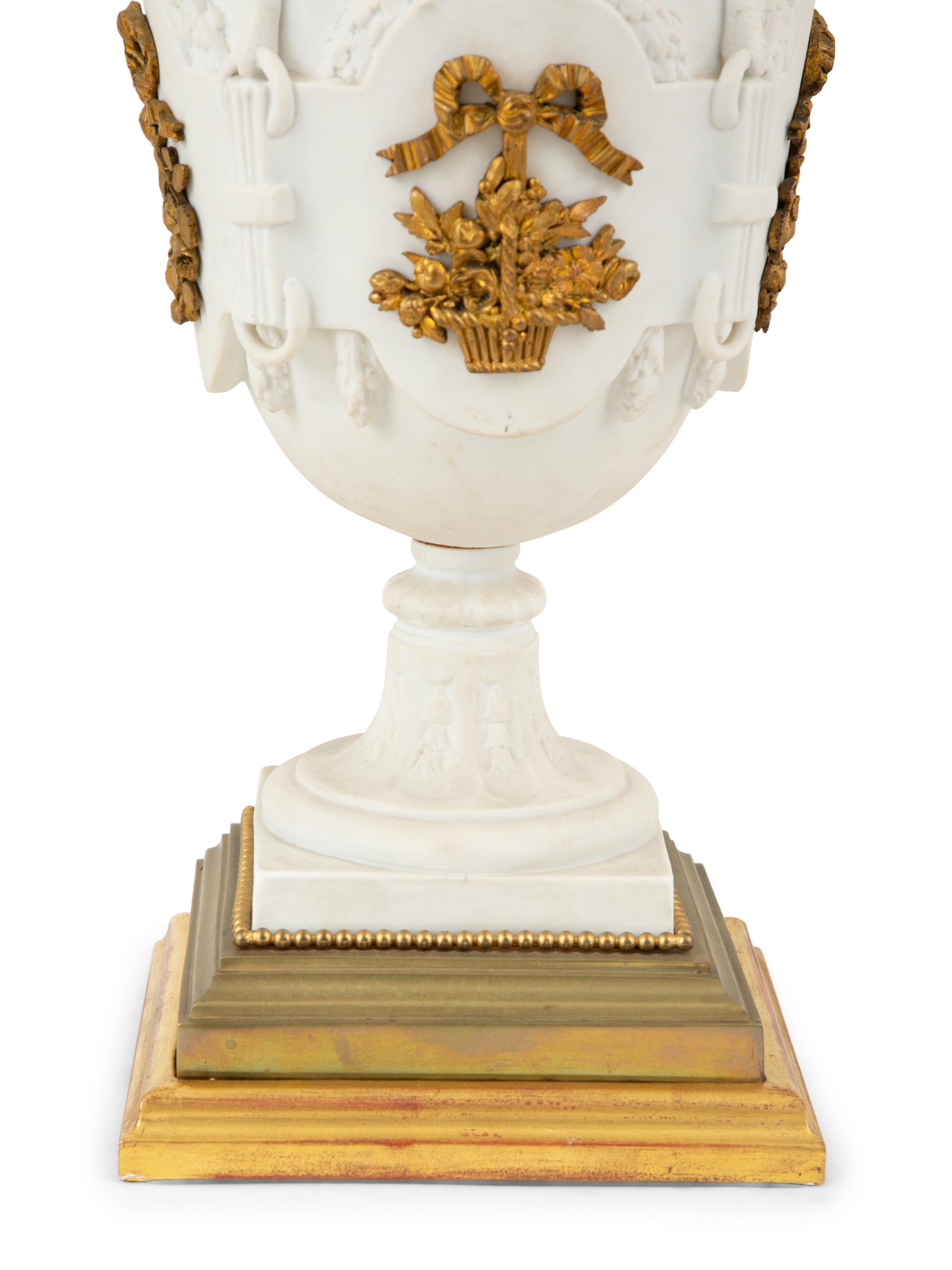 A Pair of Continental Bisque Porcelain Urns with Gilt Metal Mounts