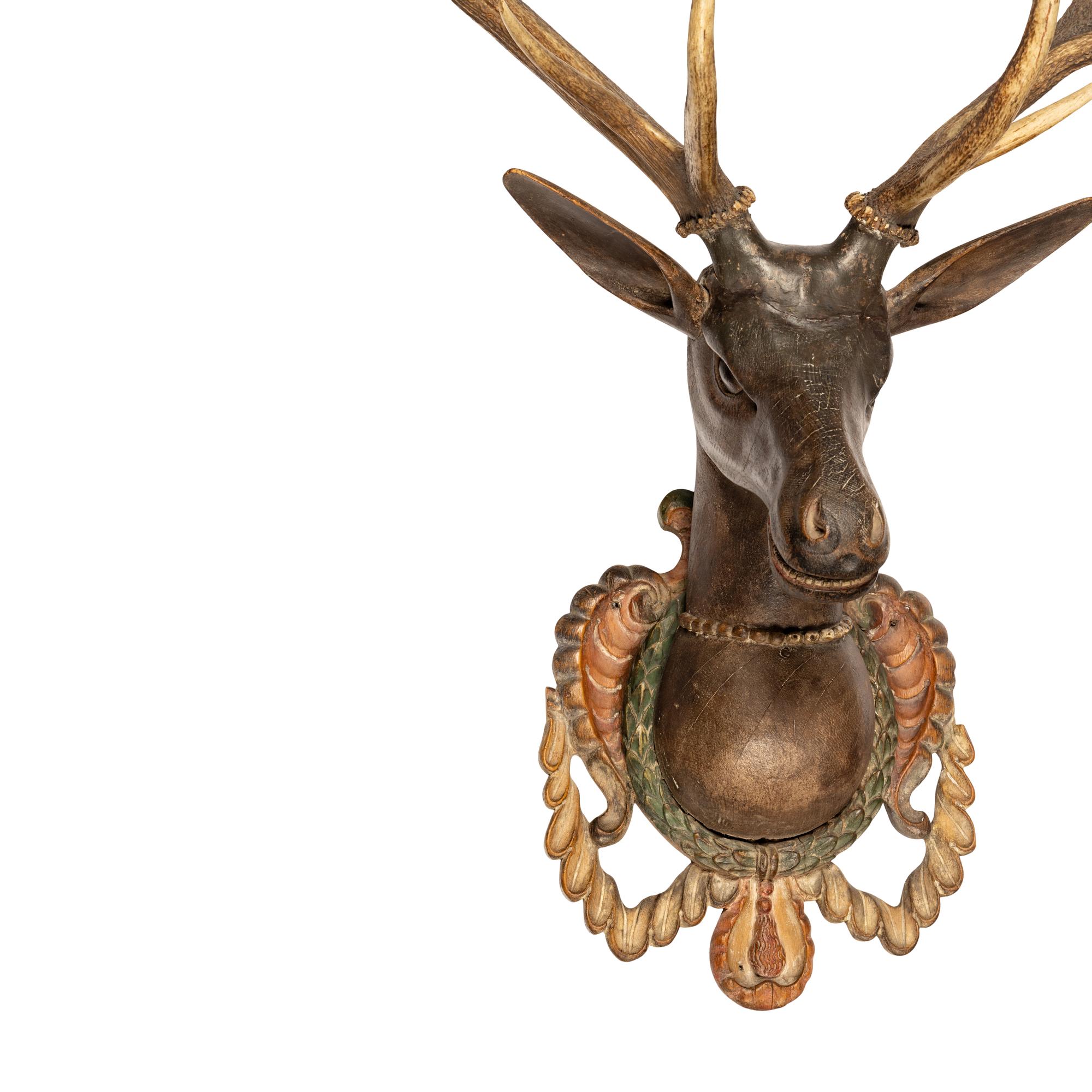 A Carved and Painted Wood and Deer Antler Mount