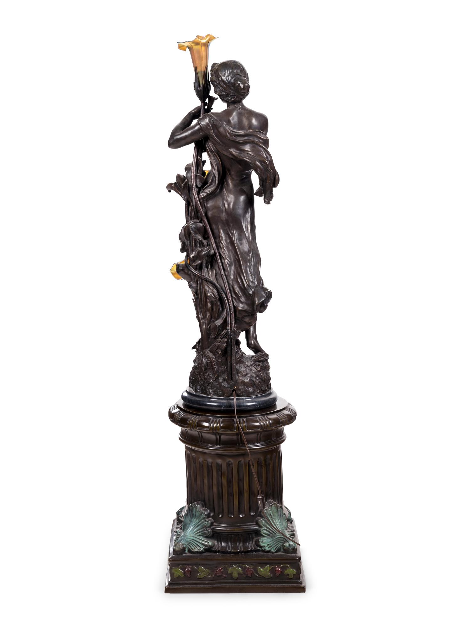 A Patinated Bronze Figural Lamp with Iridescent Glass Shades after Hippolyte François Moreau (French, 1832-1927)
