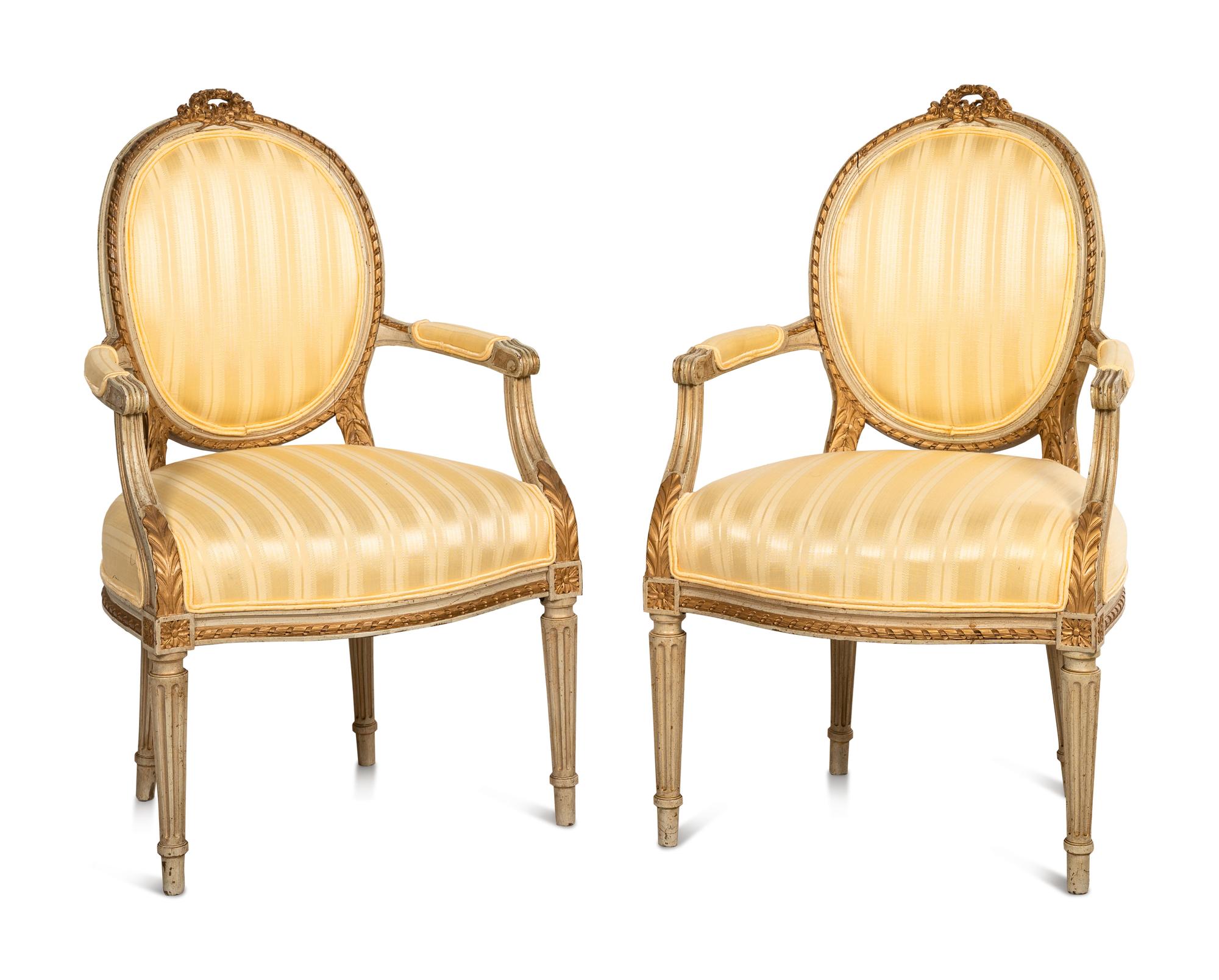 A Pair of Louis XVI Style Parcel Gilt and White Painted Fauteuils