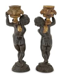 A Pair of Parcel Gilt Cast Metal Putti Candlesticks