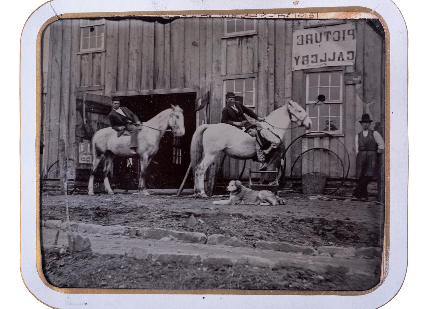 [EARLY PHOTOGRAPHY]. Half plate tintype of men, horses, & a dog outside of a "Picture Gallery."