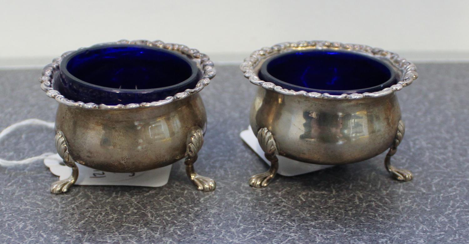 A Pair of English Silver Salts, Robert Stebbings, London, 1924, the rims with floral and foliate volute decorations and raised on three