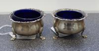 A Pair of English Silver Salts, Robert Stebbings, London, 1924, the rims with floral and foliate volute decorations and raised on three