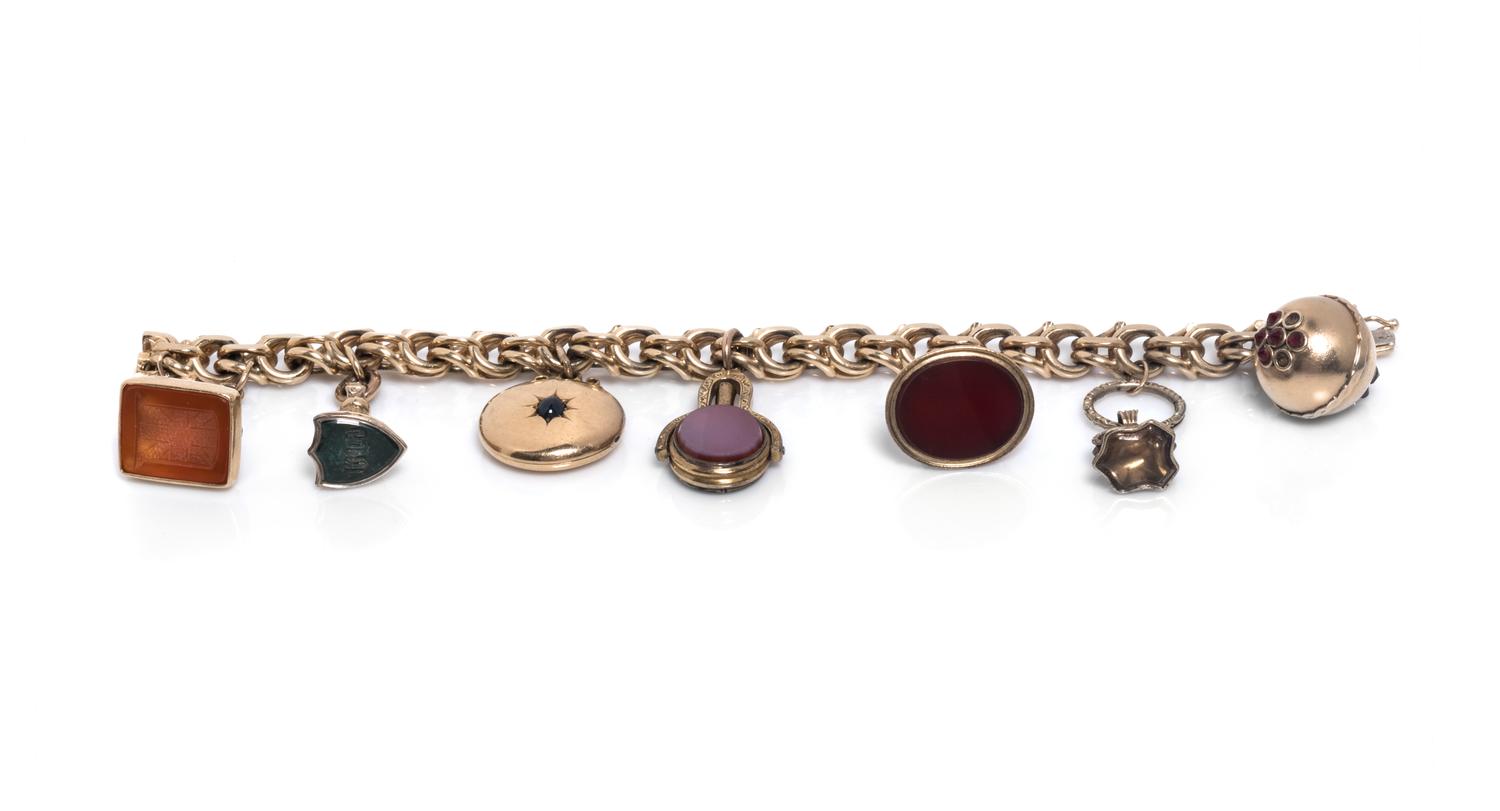 A 14 Karat Yellow Gold Bracelet with Seven Attached Fobs and Charms,