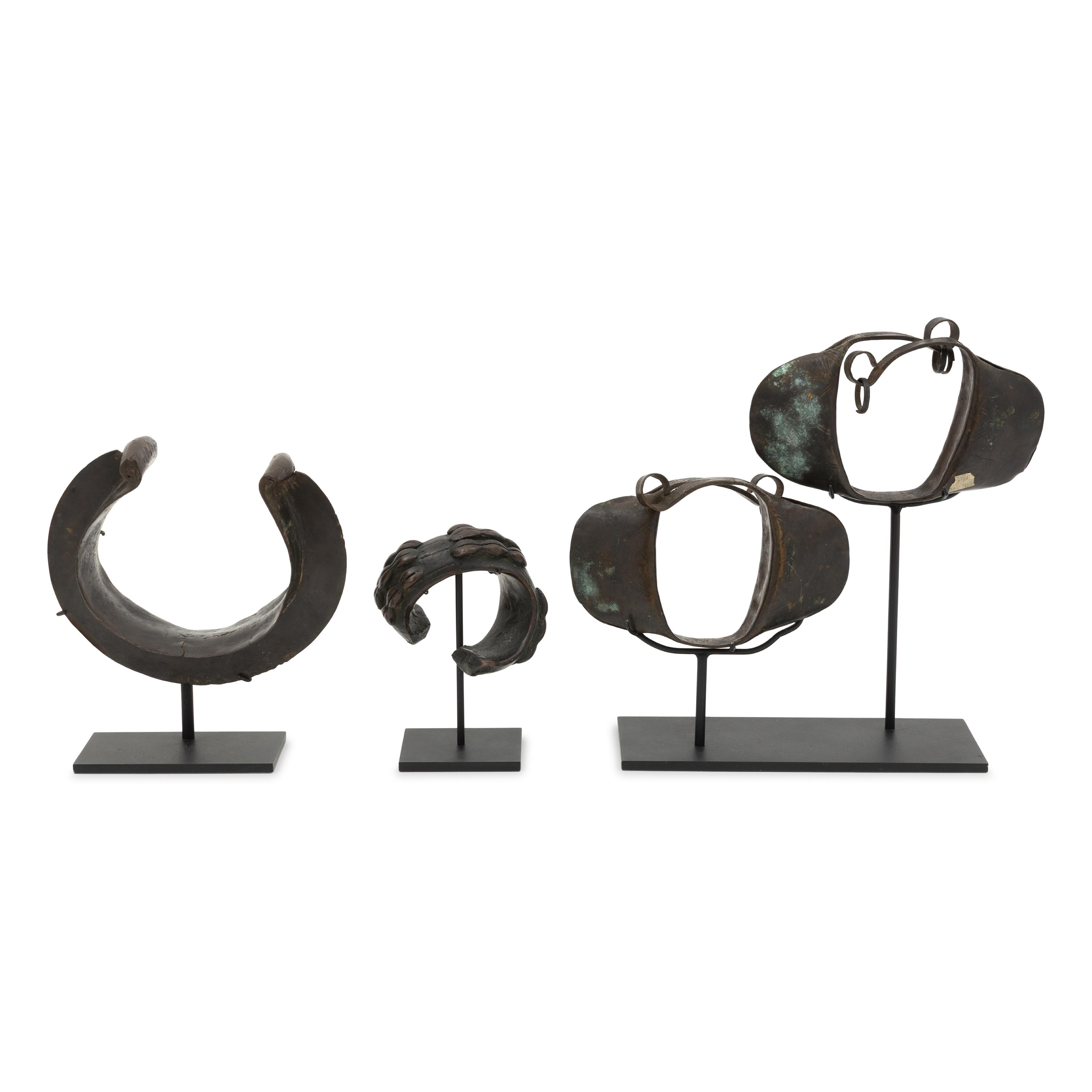 Four African Bronze Adornments on Fitted Stands