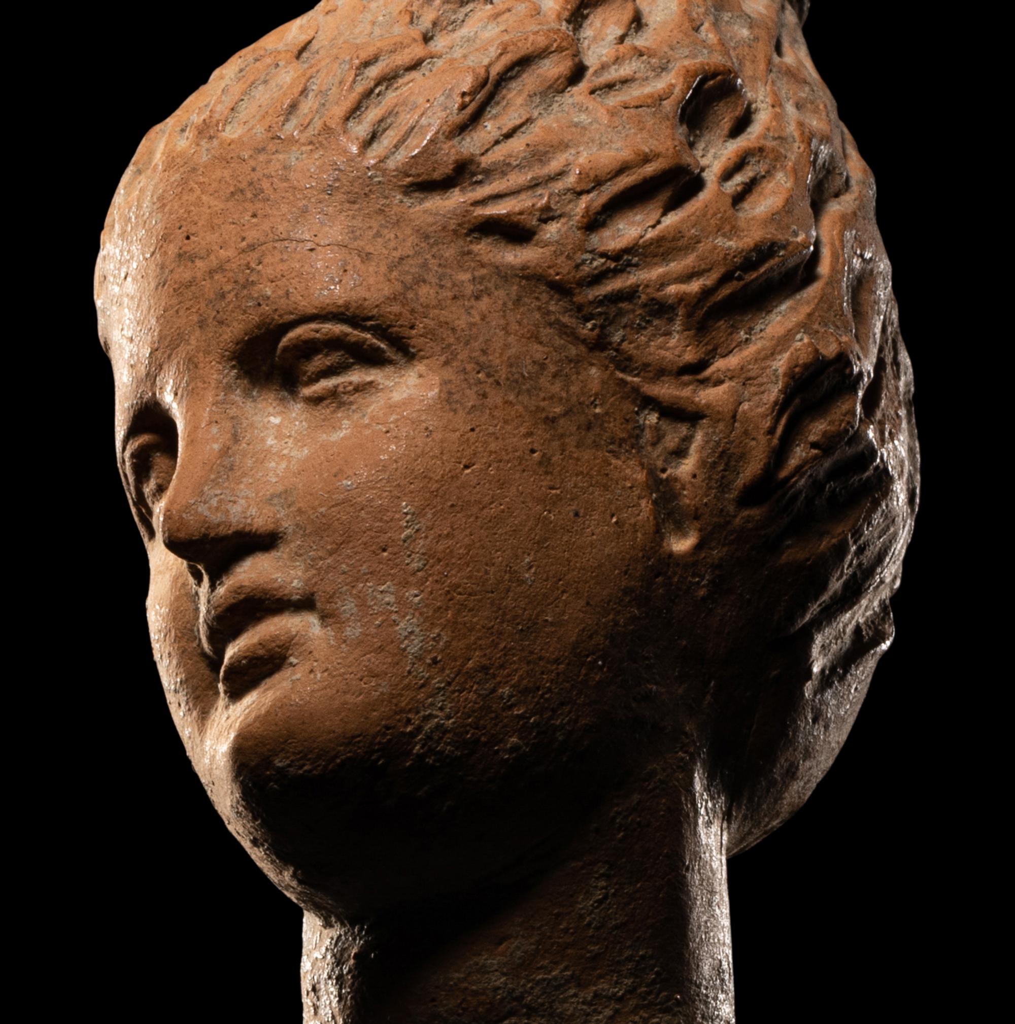 A Greek Terracotta Female Head with Melon Coiffure