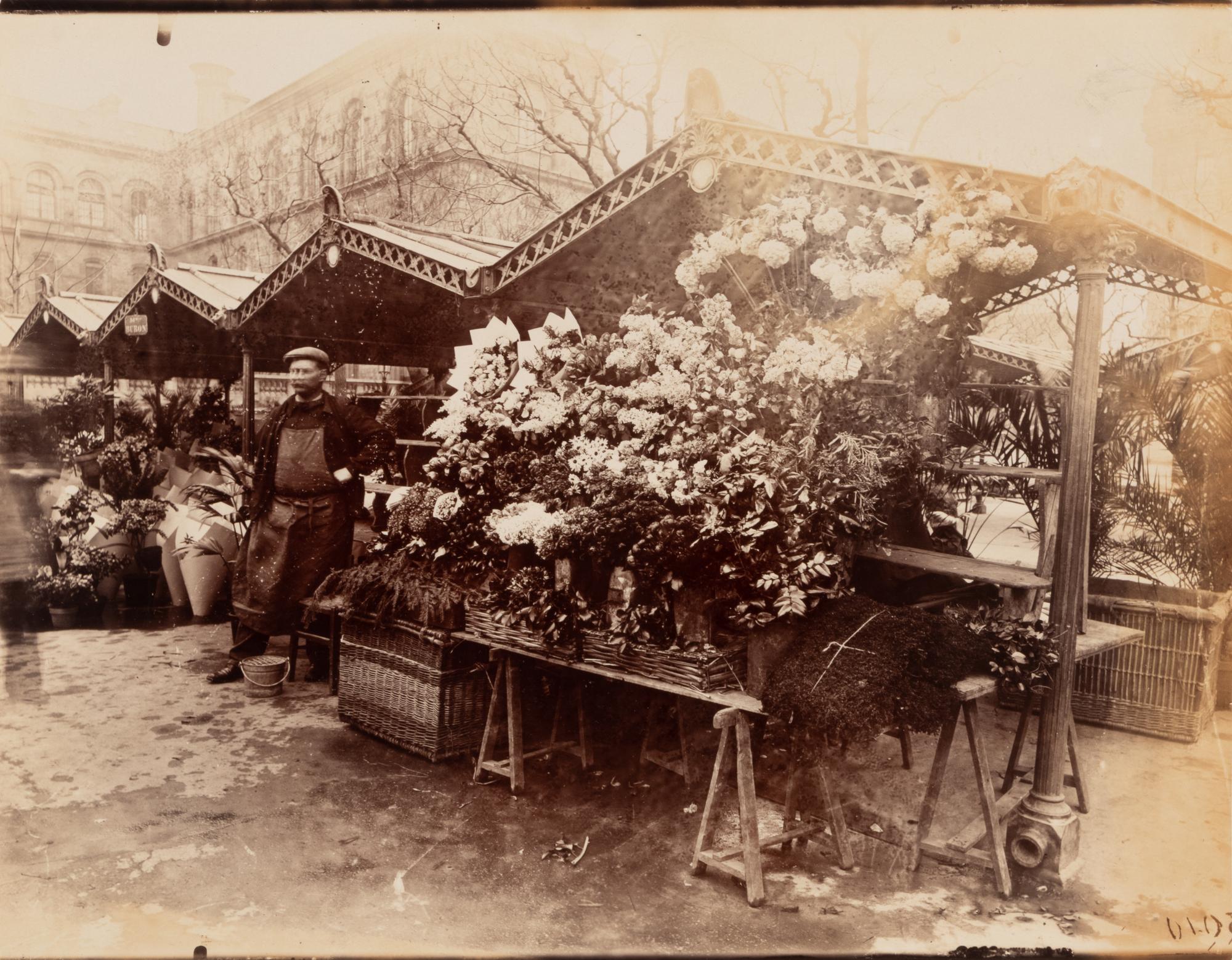 A pair of photographs ( Marché aux fleurs , circa 1900s ; Colonne Moris (Place Saint Sulpice) , 1910)