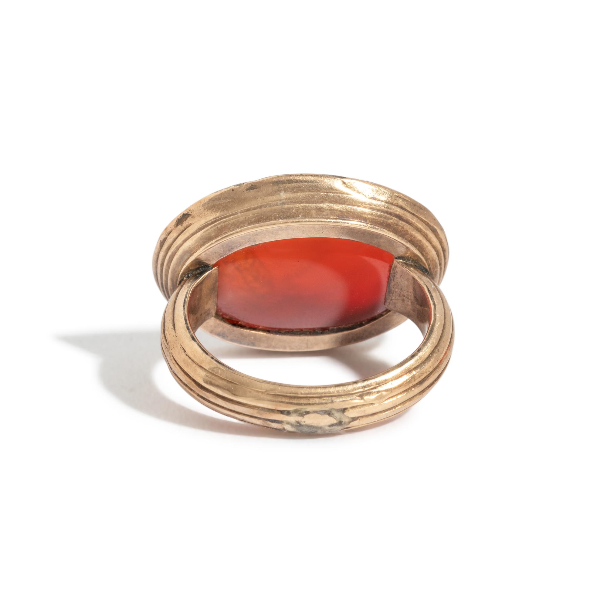 A Neoclassical Carnelian and Brass Finger Ring with a Bust of a Deity