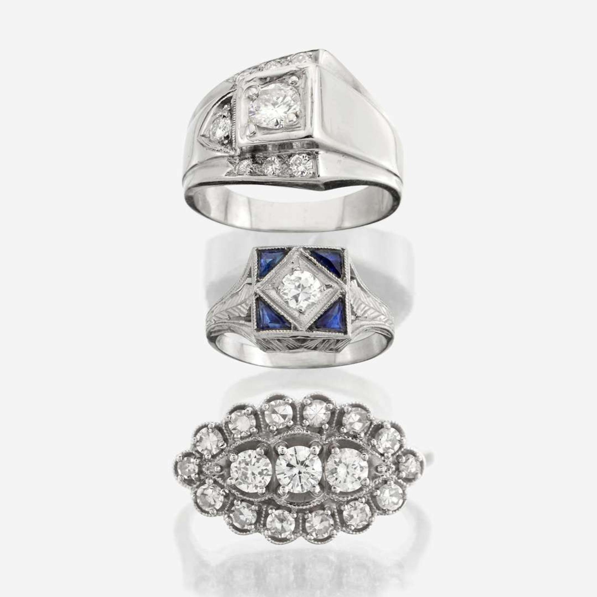 A collection of three white gold and diamond rings
