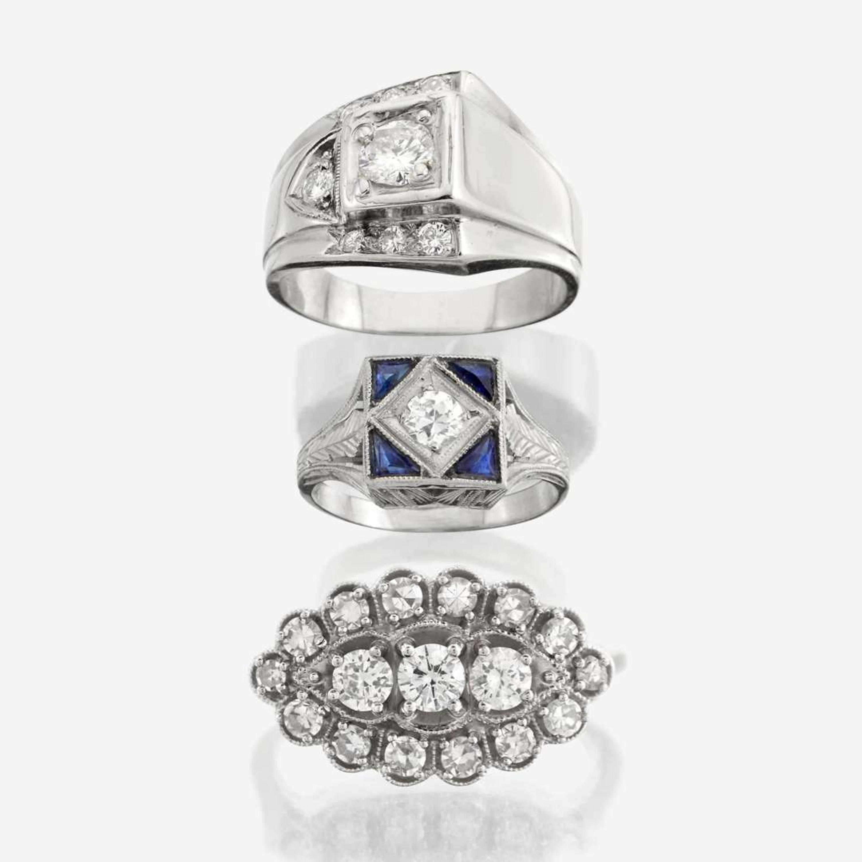 A collection of three white gold and diamond rings