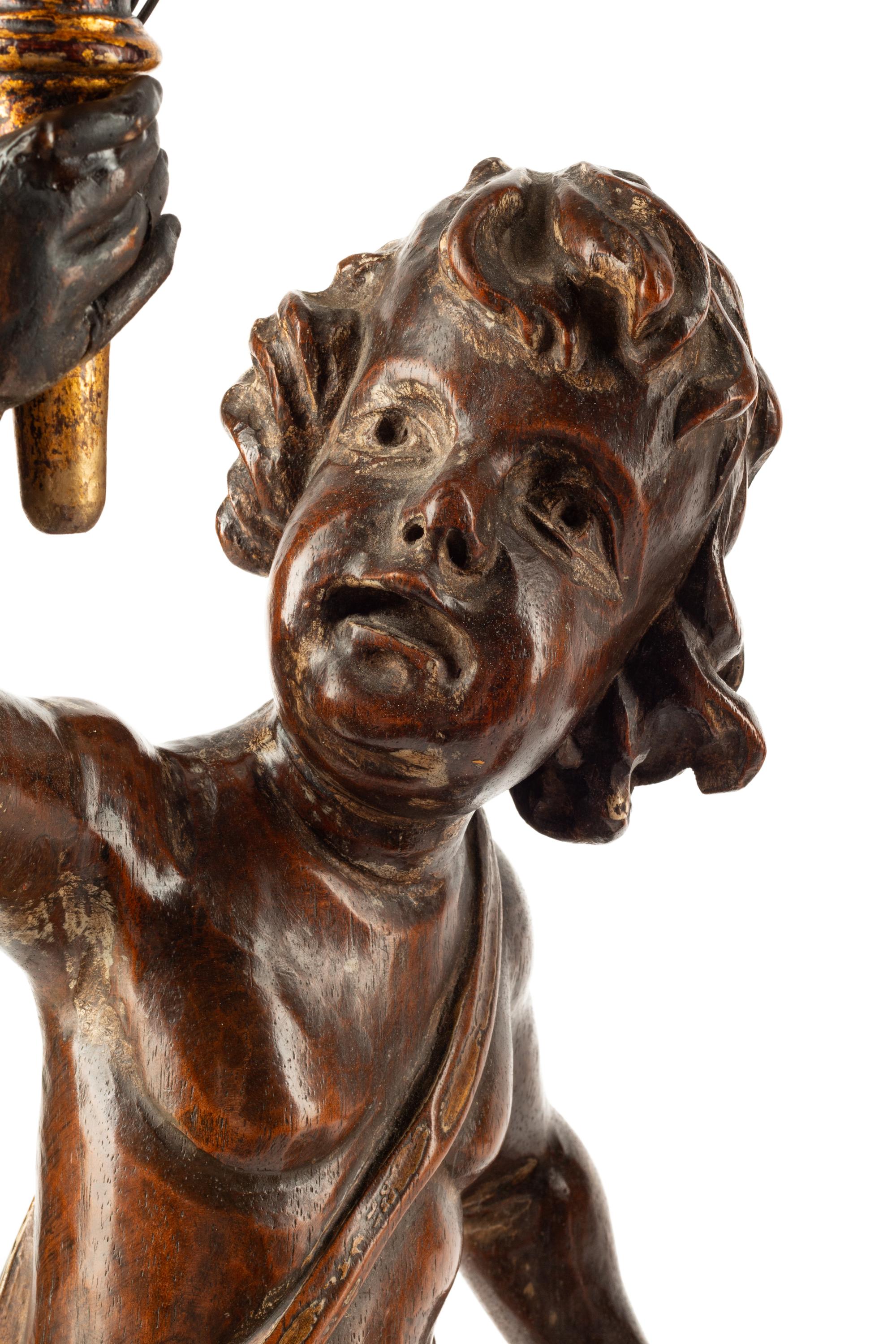 A Pair of Continental Carved Walnut Figures of Putti