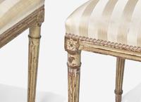 A Set of Six Louis XVI Cream-Painted and Parcel Gilt Dining Chairs