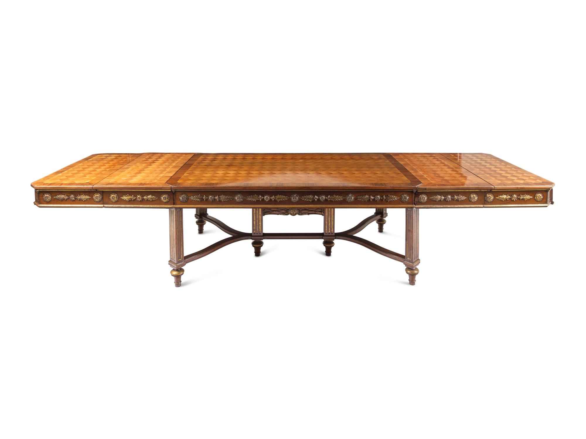 A Louis XVI Style Parcel Gilt Parquetry and Walnut Dining Table
