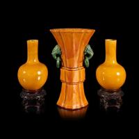 A pair of Chinese yellow-glazed bottle vases and a yellow-glazed gu-form vase 黄釉瓷瓶及木底座两对和黄釉觚式花瓶一件