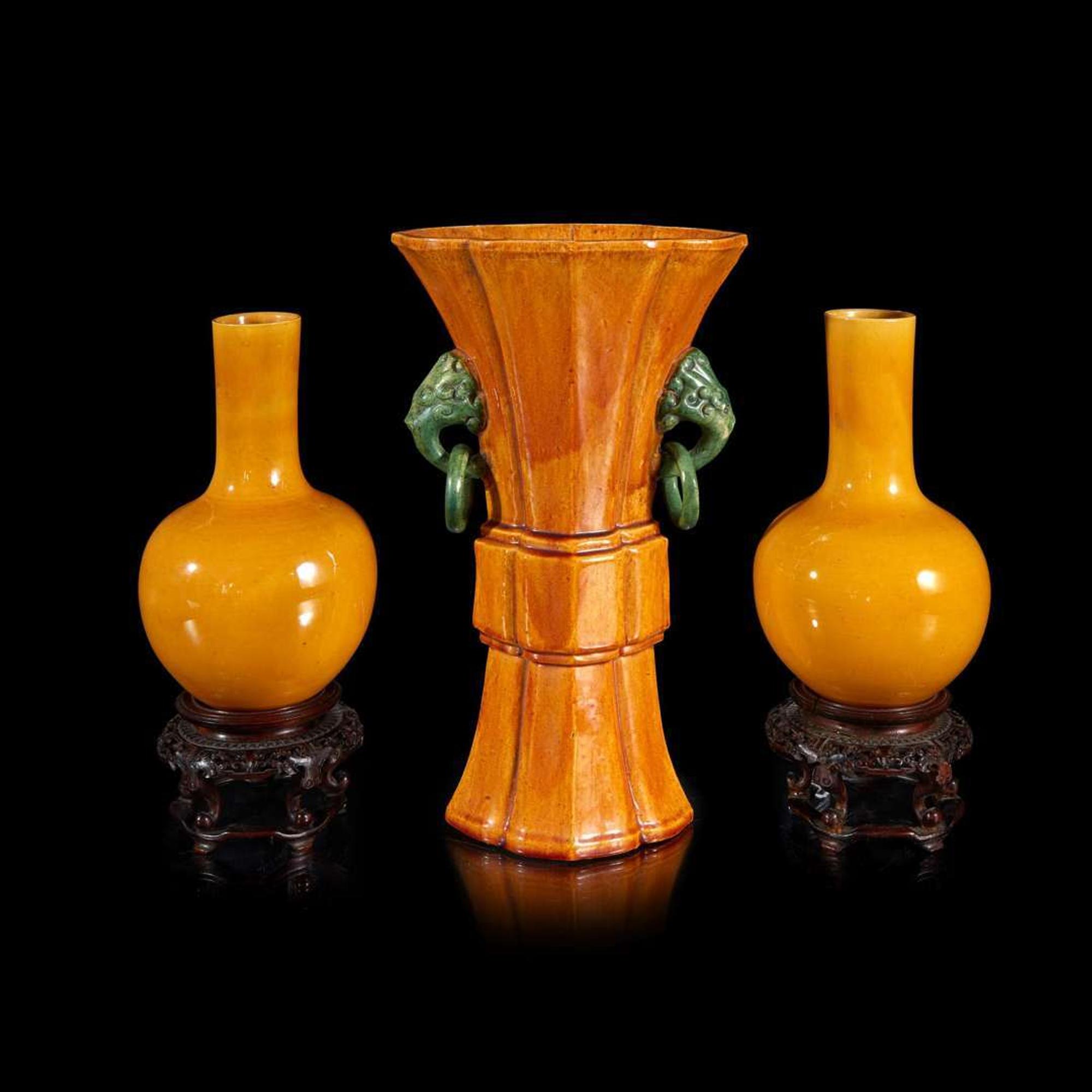 A pair of Chinese yellow-glazed bottle vases and a yellow-glazed gu-form vase 黄釉瓷瓶及木底座两对和黄釉觚式花瓶一件