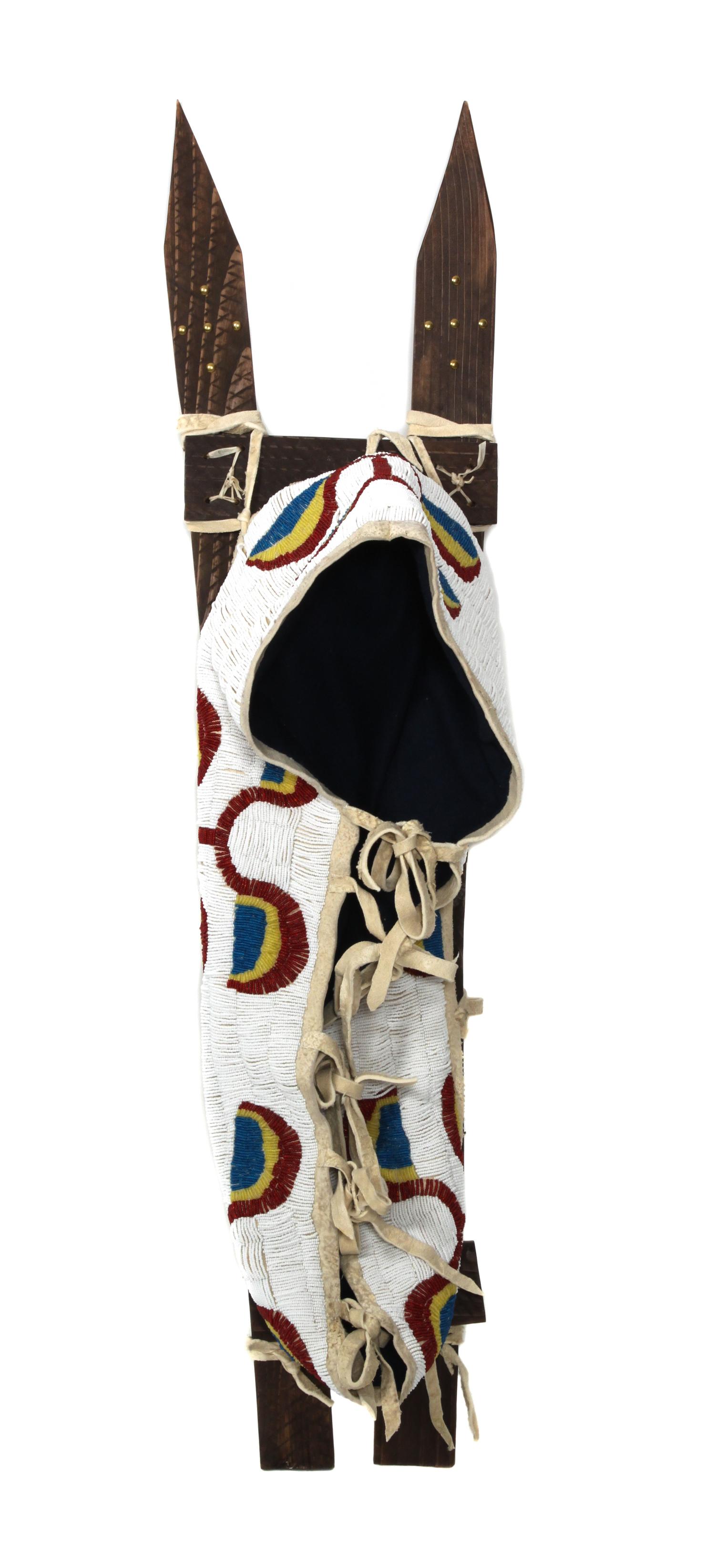 A Northern Plains Style Beaded Cradle on Sticks Length over all 42 inches