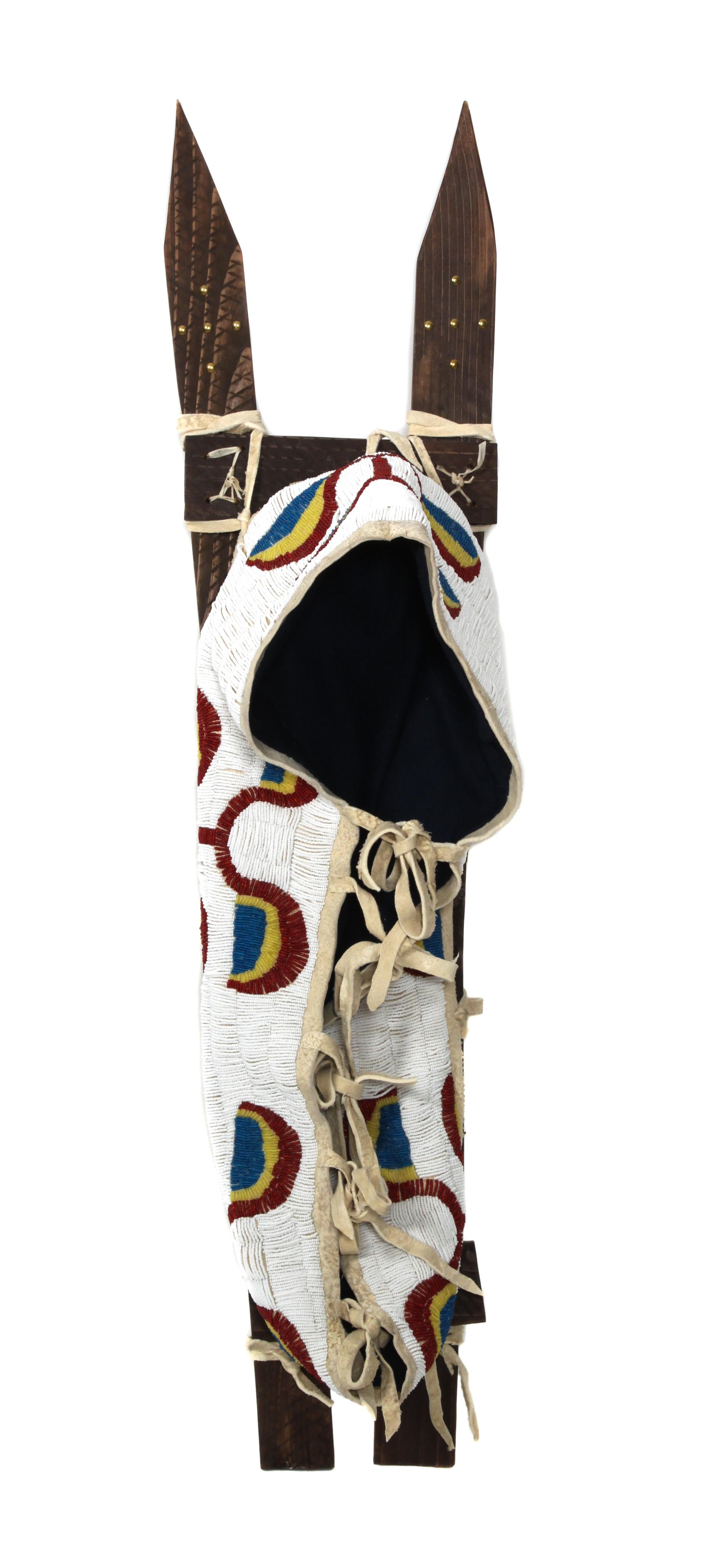 A Northern Plains Style Beaded Cradle on Sticks Length over all 42 inches