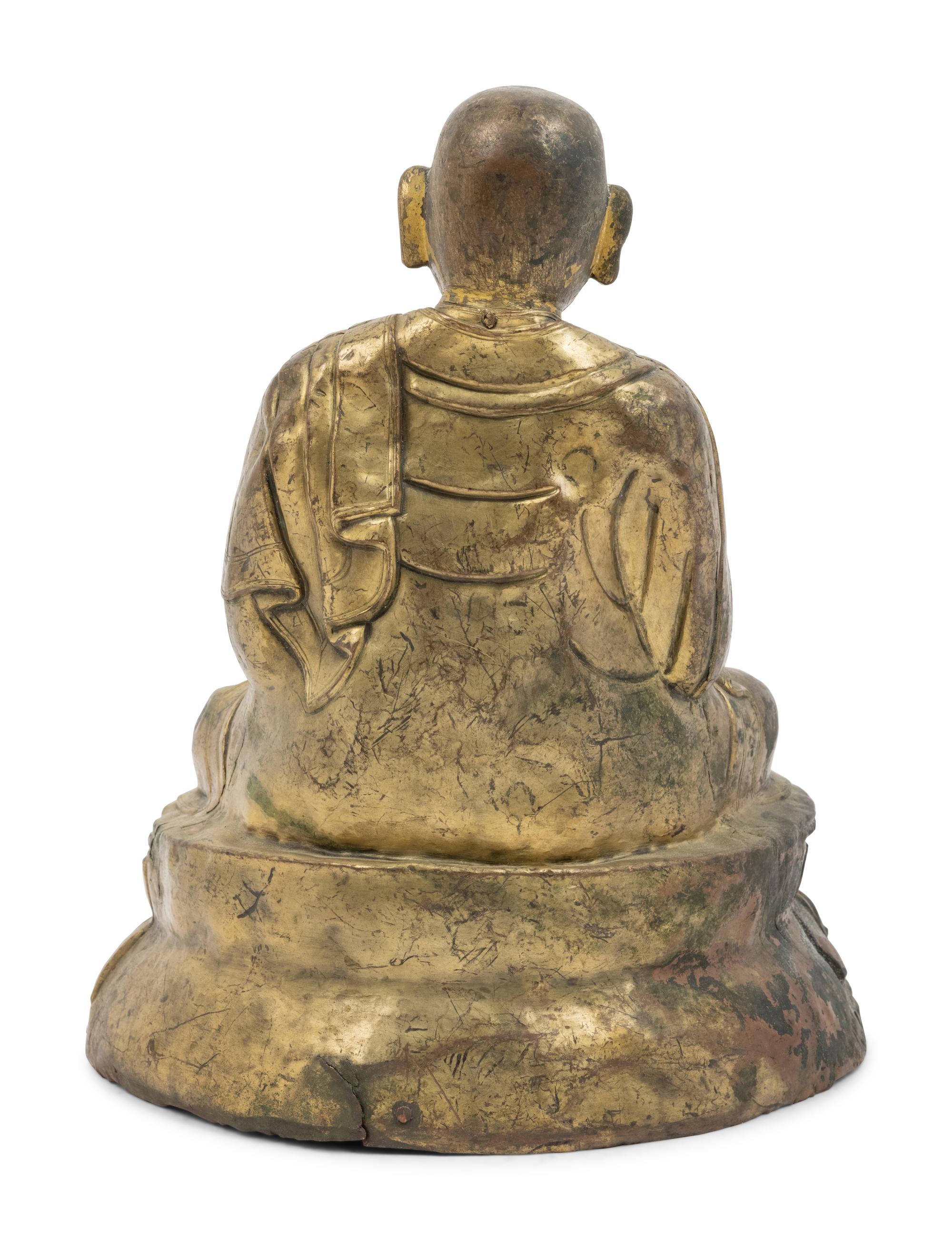 A Large Tibetan Parcel Gilt Bronze Repoussé Figure of a Seated Monk