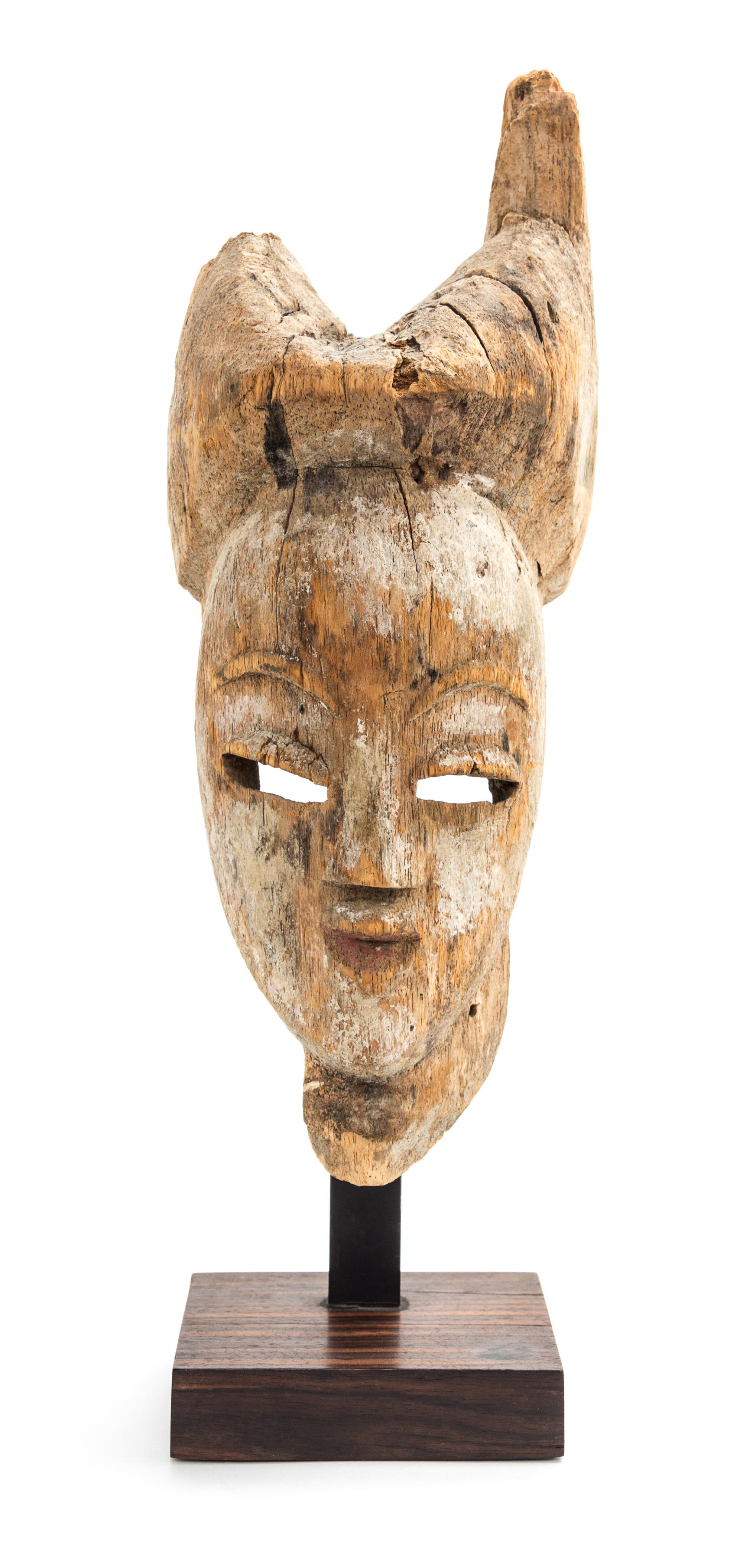 An African Carved Wooden Masque. Height 12 1/2 x width 4 3/4 x depth 5 1/2 inches.