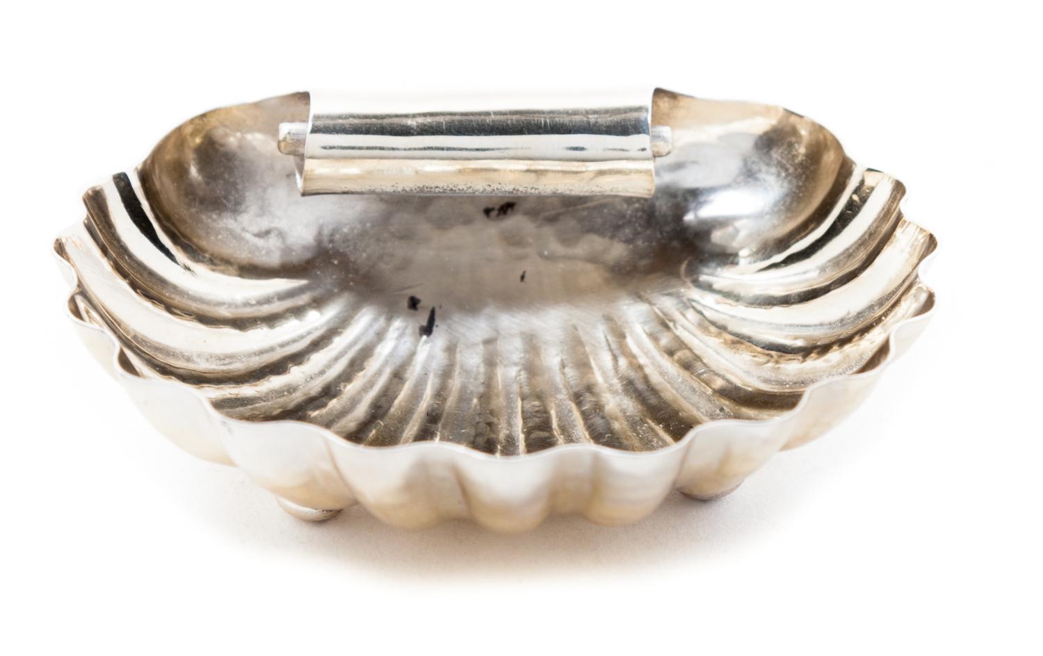 An Italian Silver Dish, Buccellati, of shell form with scalloped edges and a scrolling handle, raised on pad feet
