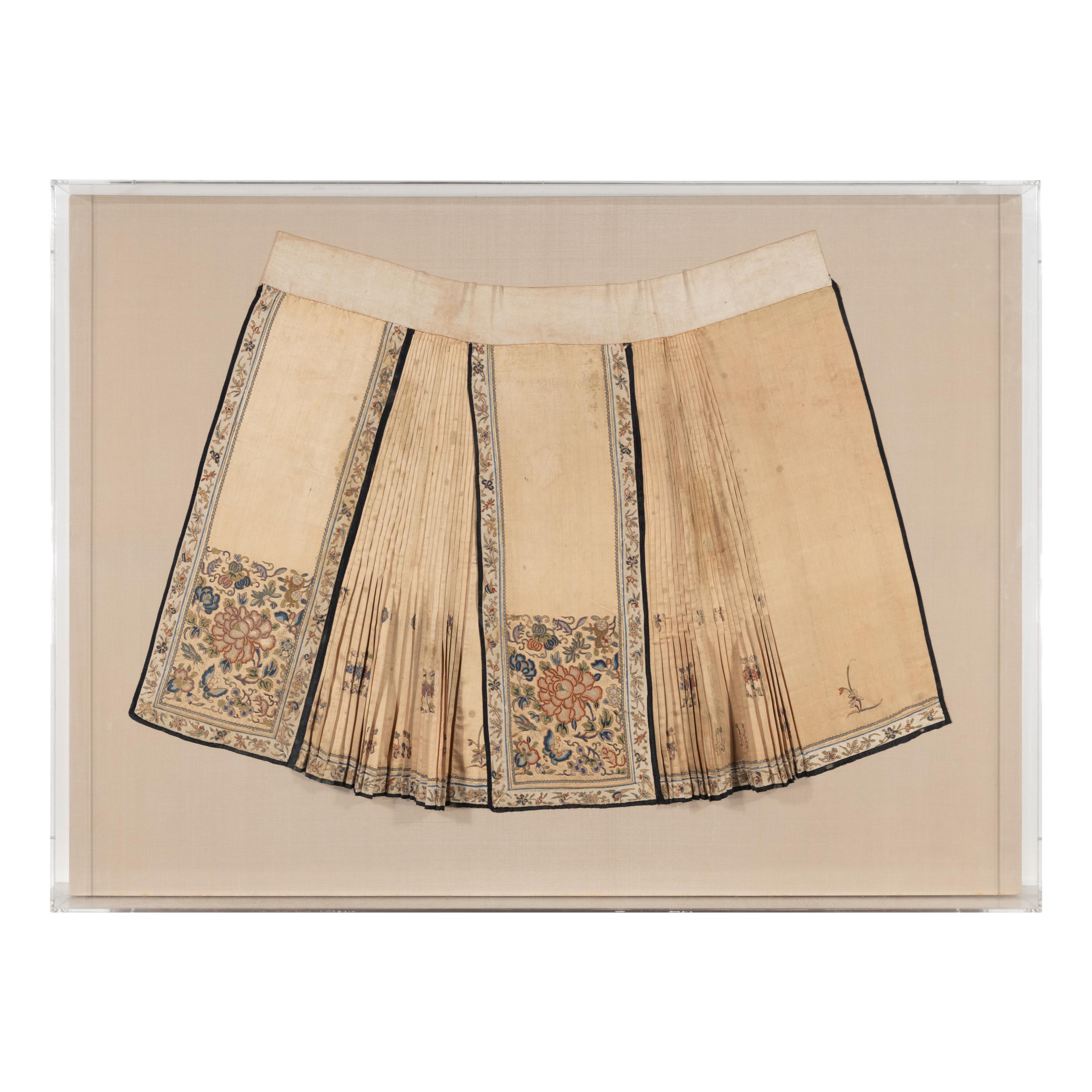 A Chinese Apricot Ground Embroidered Silk Apron Skirt and A Blue Ground Embroidered Silk Hat, 19th Century — 晚清 杏色地繡牡丹紋馬面裙及藍底繡瓜果紋帽