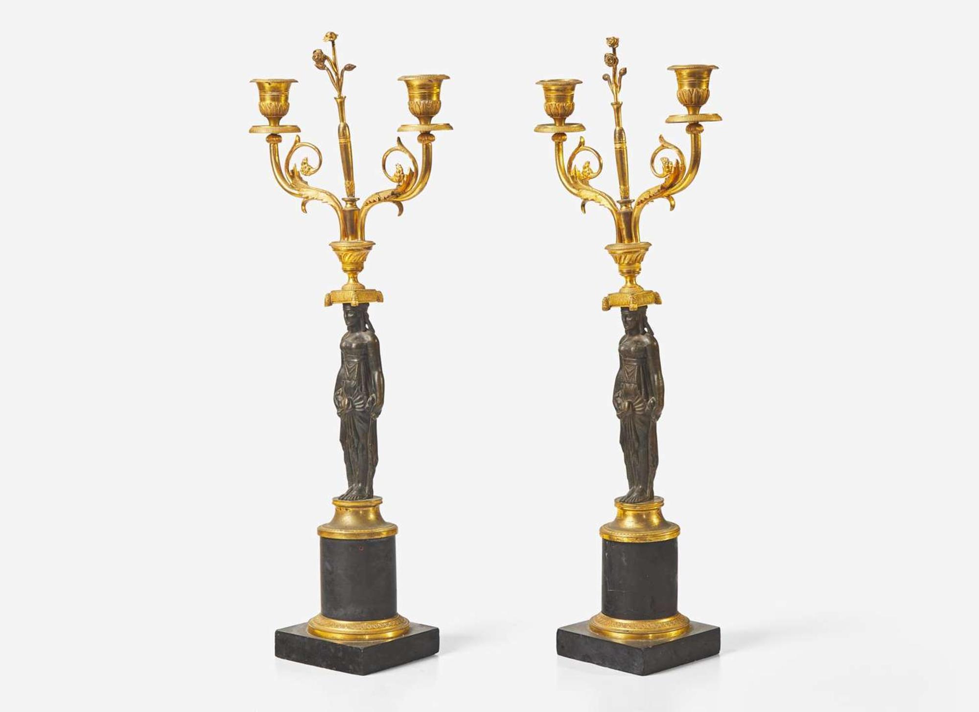 A pair of French Empire gilt and patinated bronze candelabras, first quarter 19th century