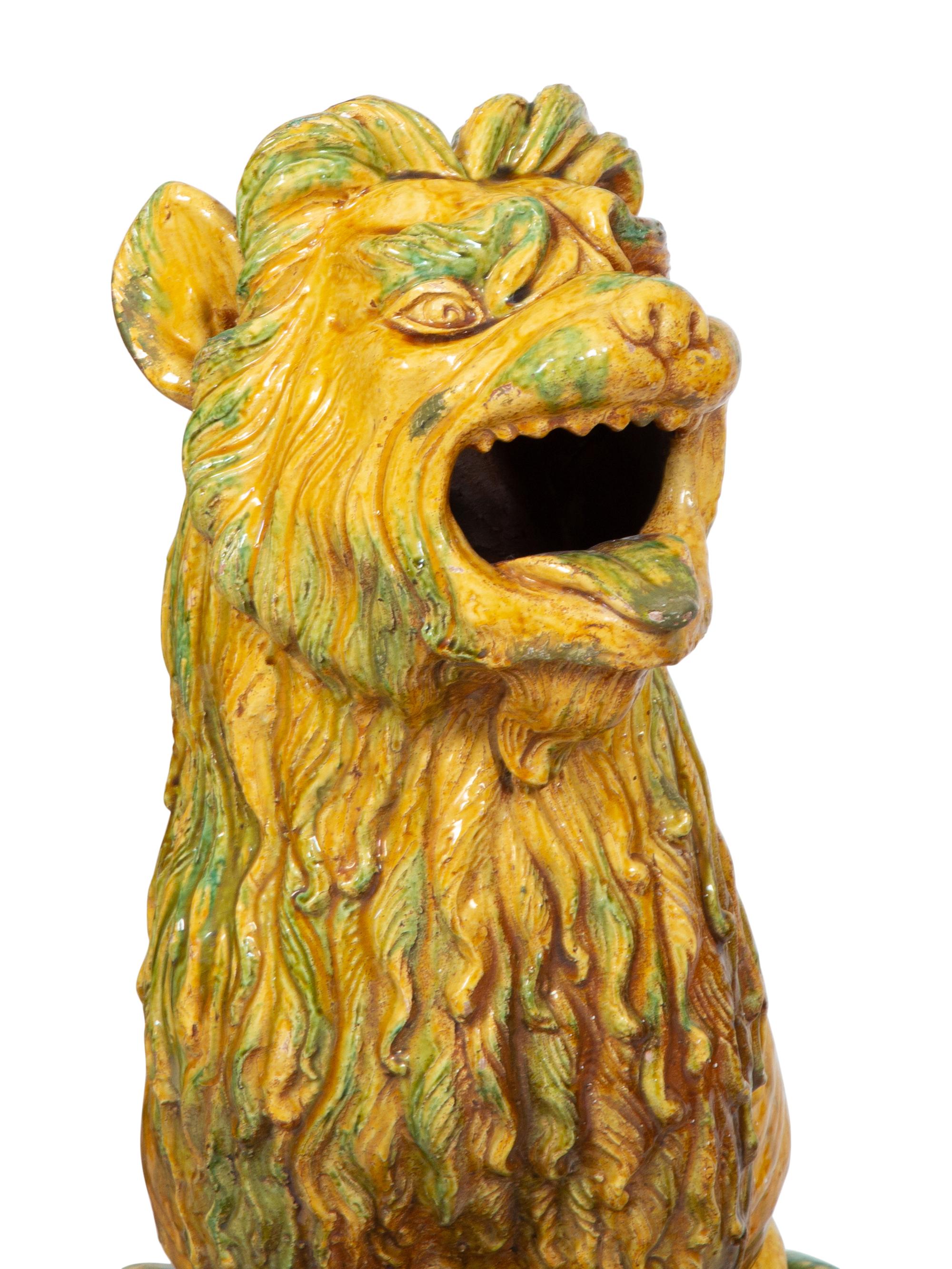 A Pair of Italian Yellow and Green Glazed Ceramic Figures of Seated Lions