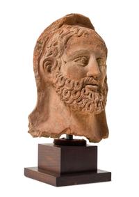 An Etruscan Terra Cotta Votive Head of a Bearded Man Height 12 1/4 inches. — CIRCA 4TH-3RD CENTURY B.C.E.