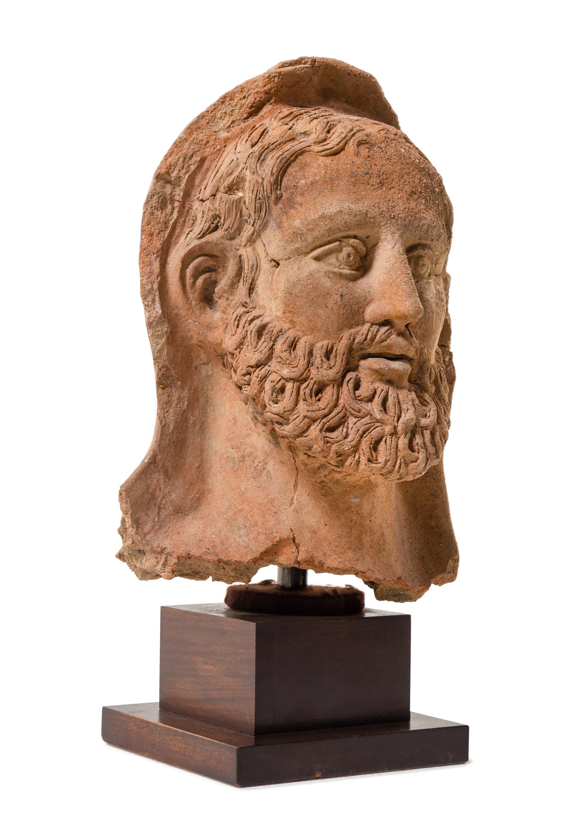An Etruscan Terra Cotta Votive Head of a Bearded Man Height 12 1/4 inches. — CIRCA 4TH-3RD CENTURY B.C.E.