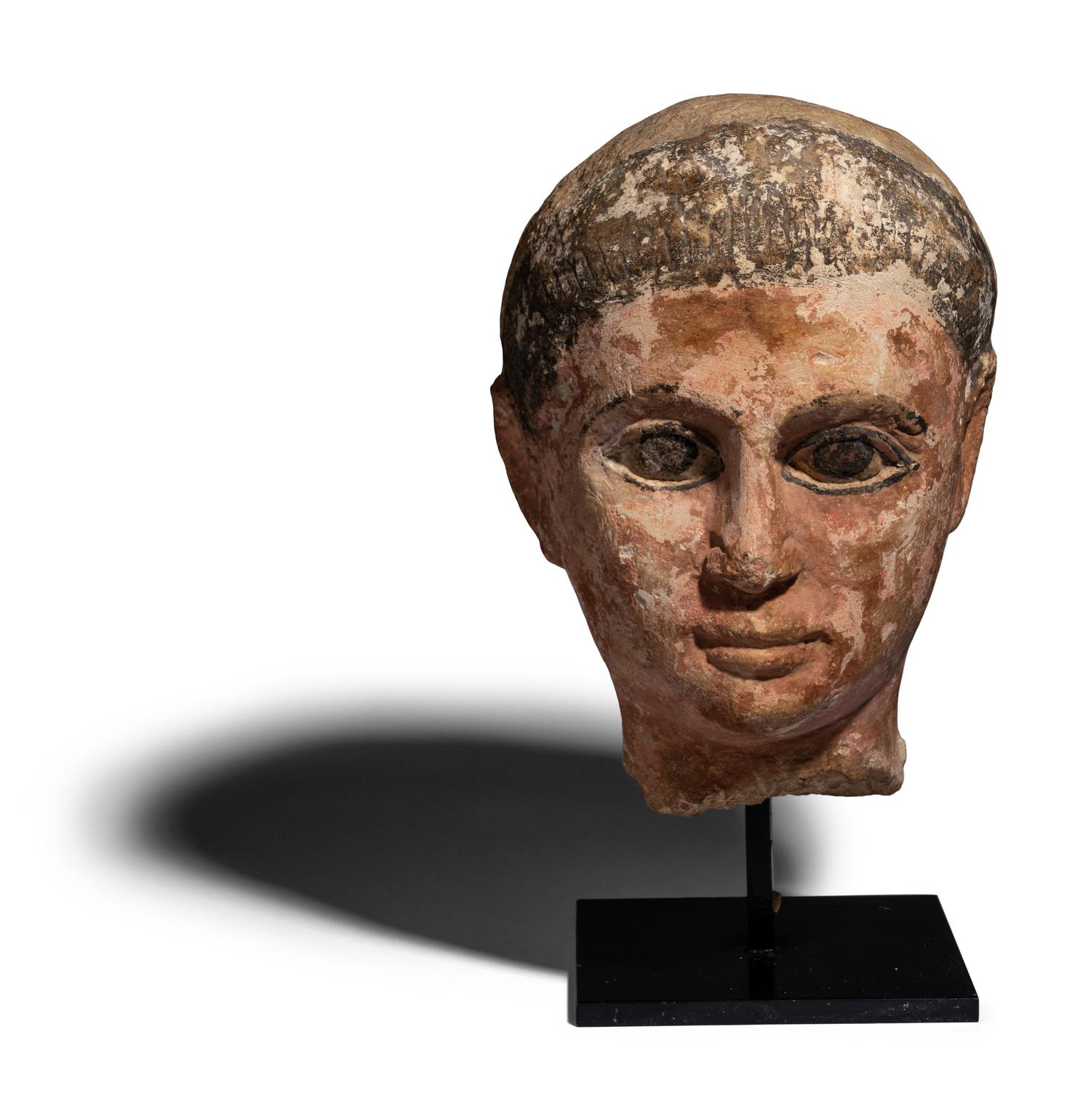 An Egyptian Painted Limestone Head of a Youth