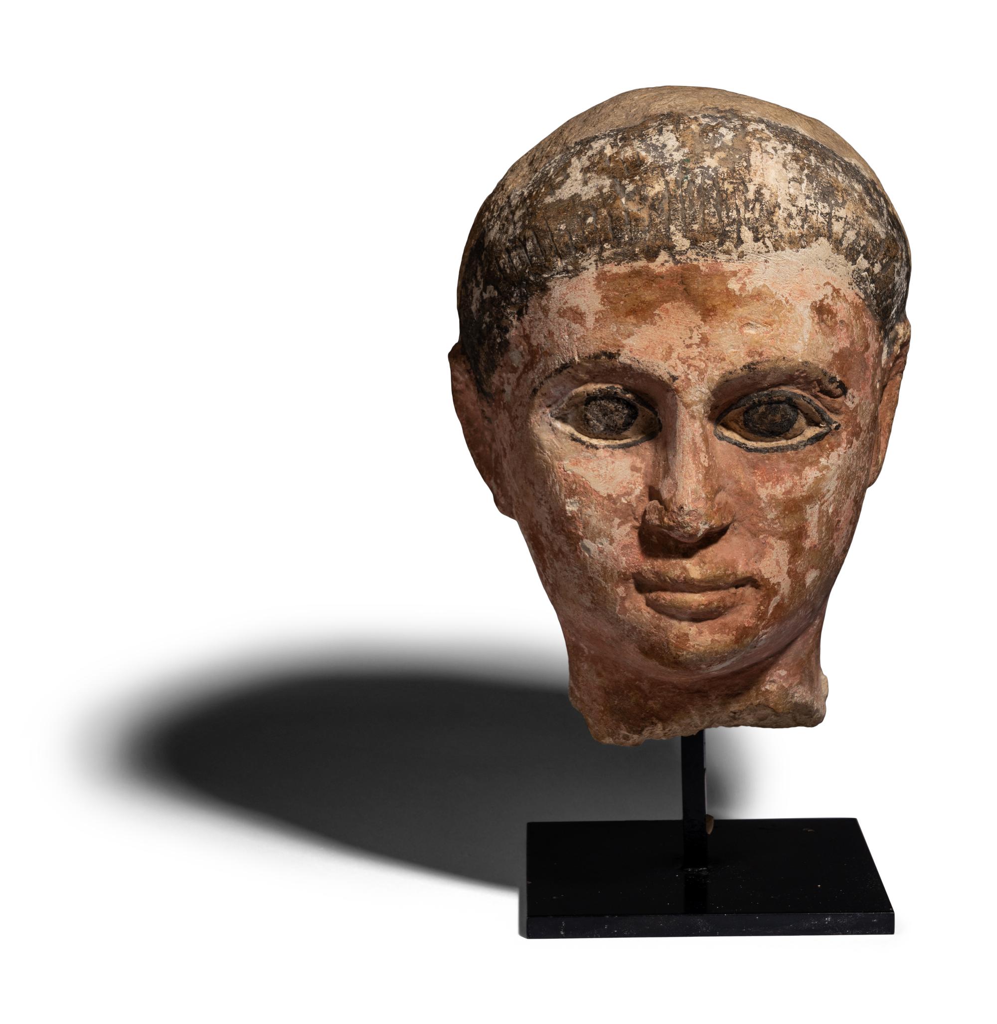 An Egyptian Painted Limestone Head of a Youth